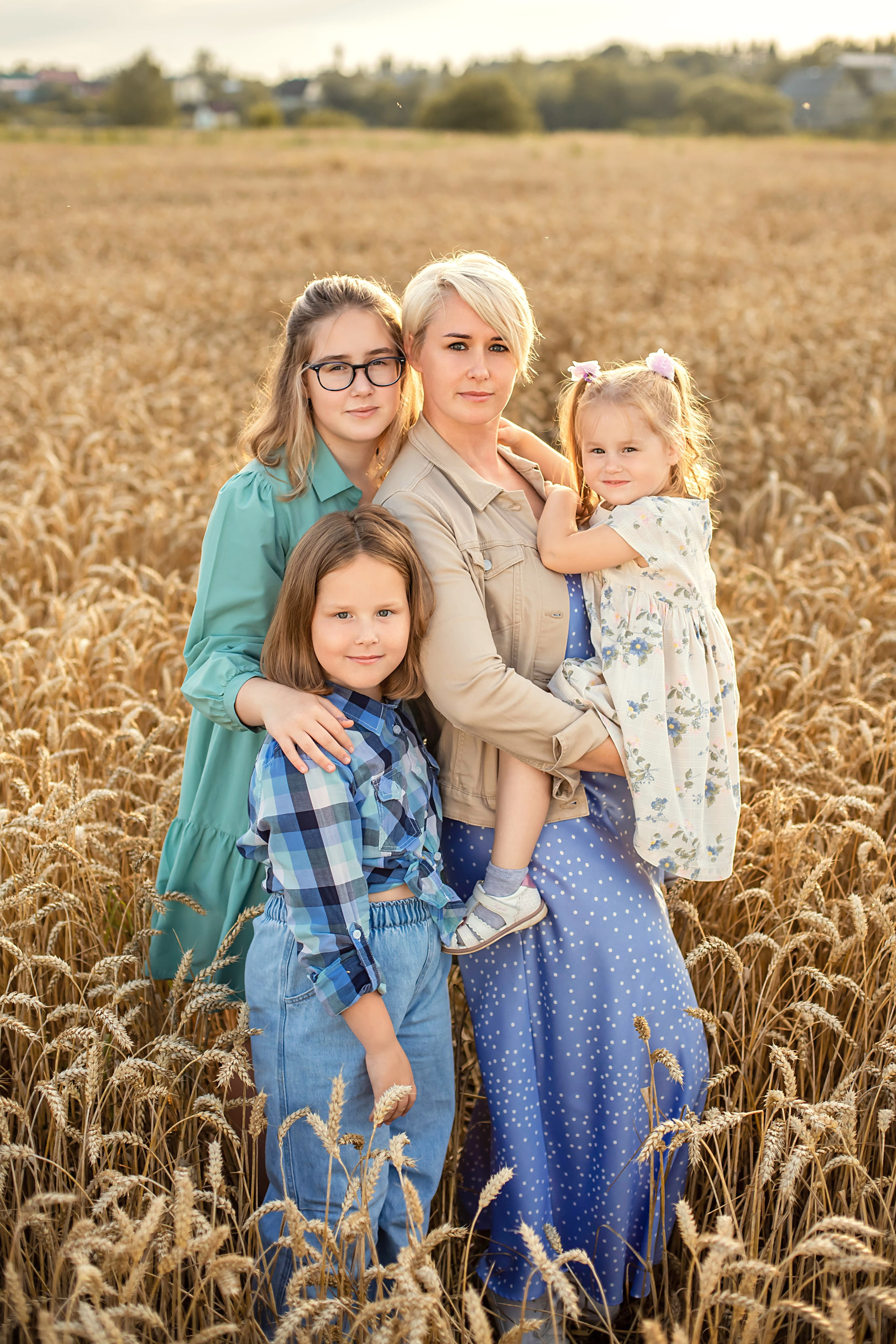 Семейная нежная съемка пожилых родителей и взрослых детей. В центре сюжета сидит мать на кресле, сзади которой расположился любящий отец с двумя дочерями