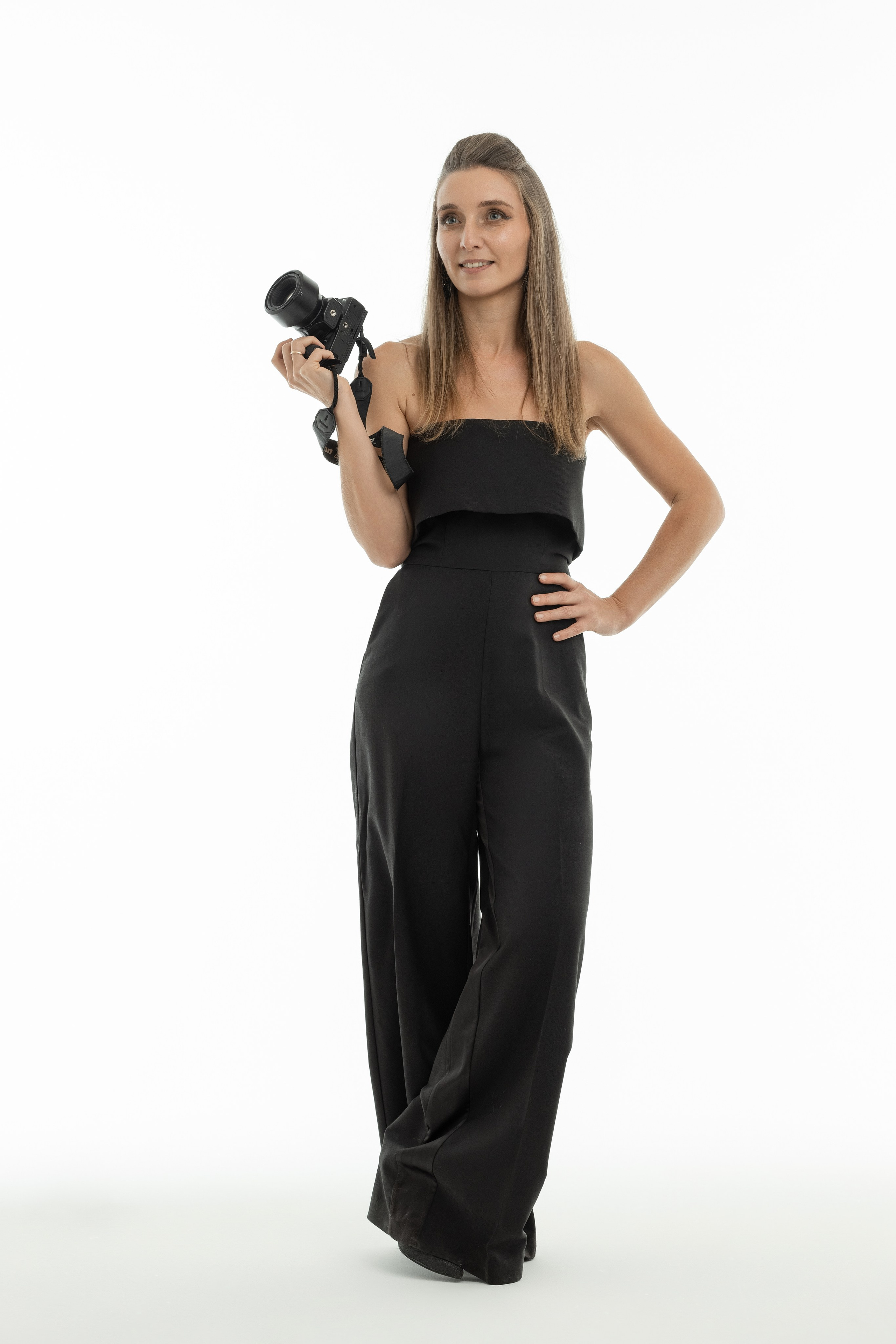 Фотограф беременности и семей стоит с фотоаппаратом в руках