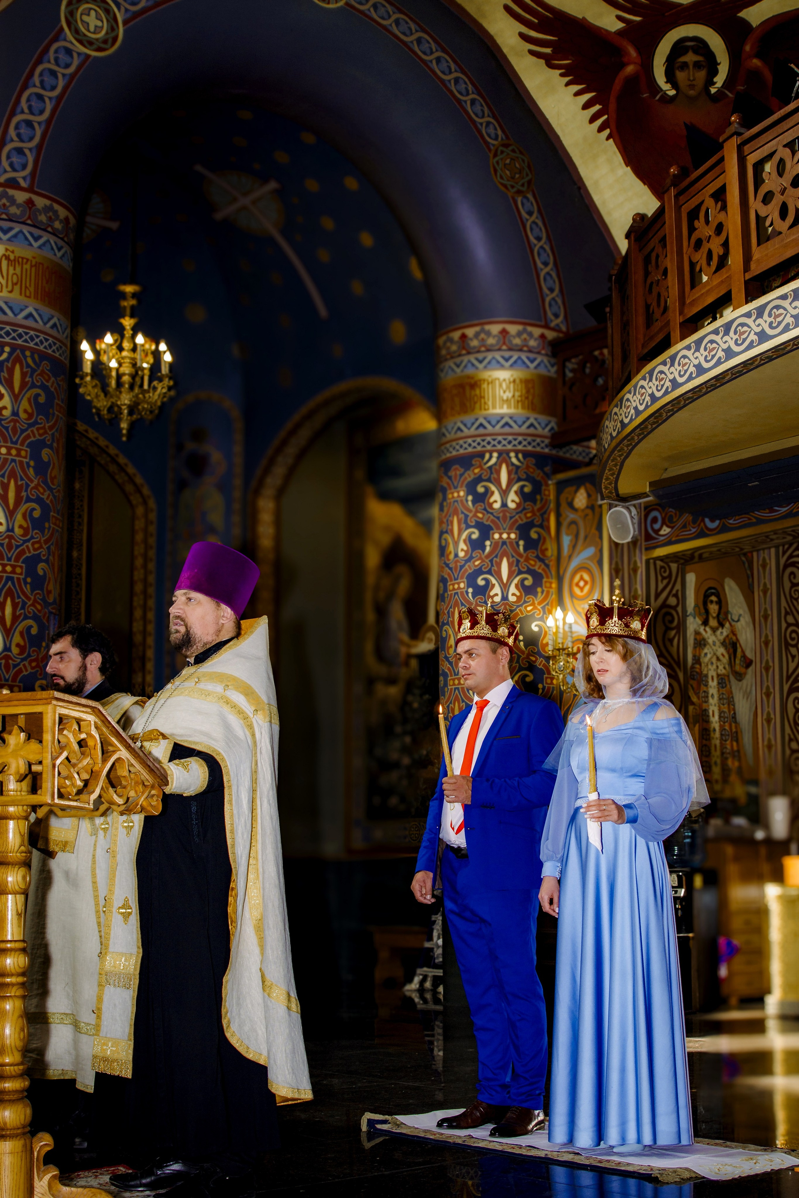 Жених и невеста в голубых одеждах в храме на церемонии обряда венчание