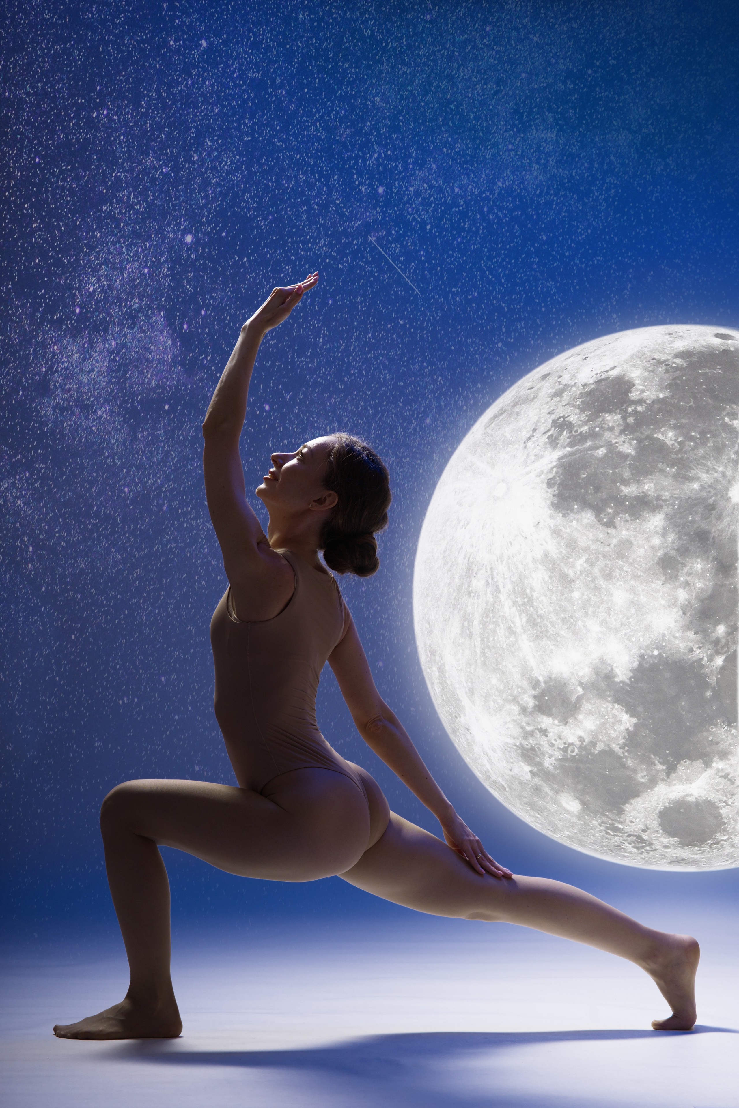 Арт-фотосессия йоги на фоне Луны: спортивный фотограф в Тюмени, создание контента для инструкторов. Асана в глубоком синем свете с использованием световых декораций.