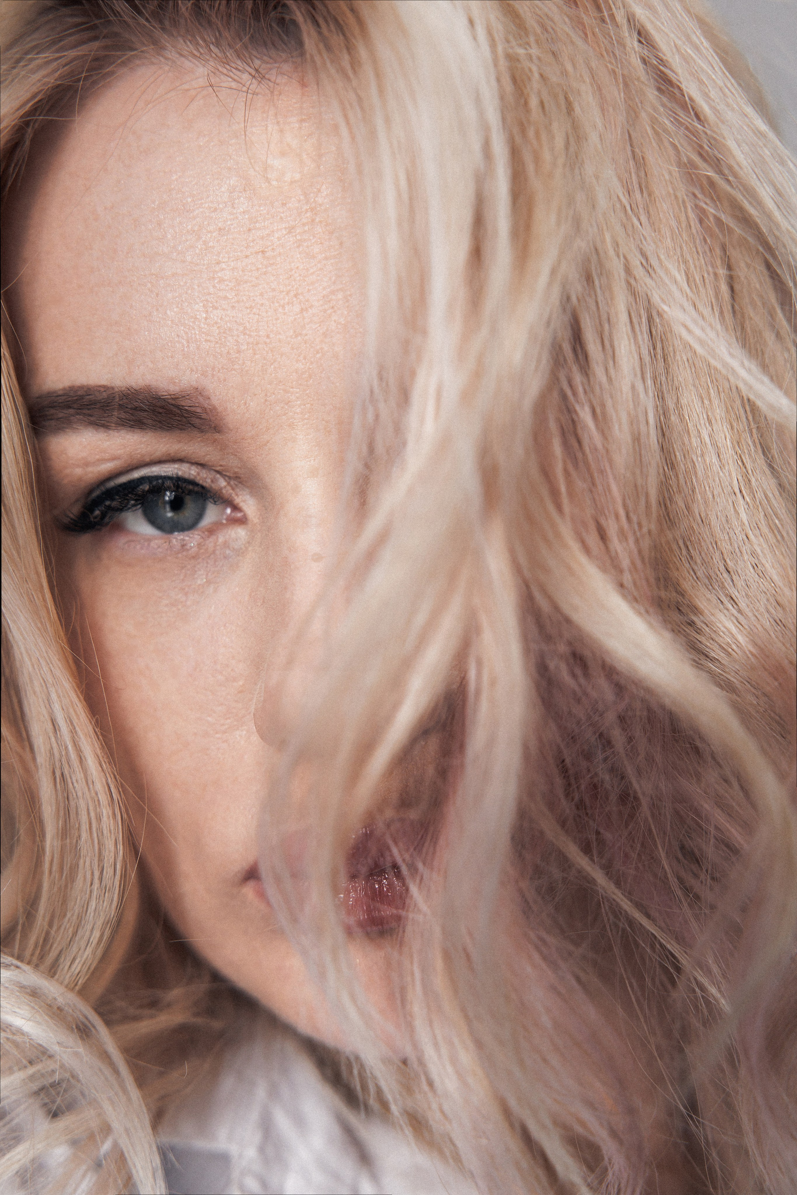 Лицо девушки с голубыми глазами и светлыми волосами 