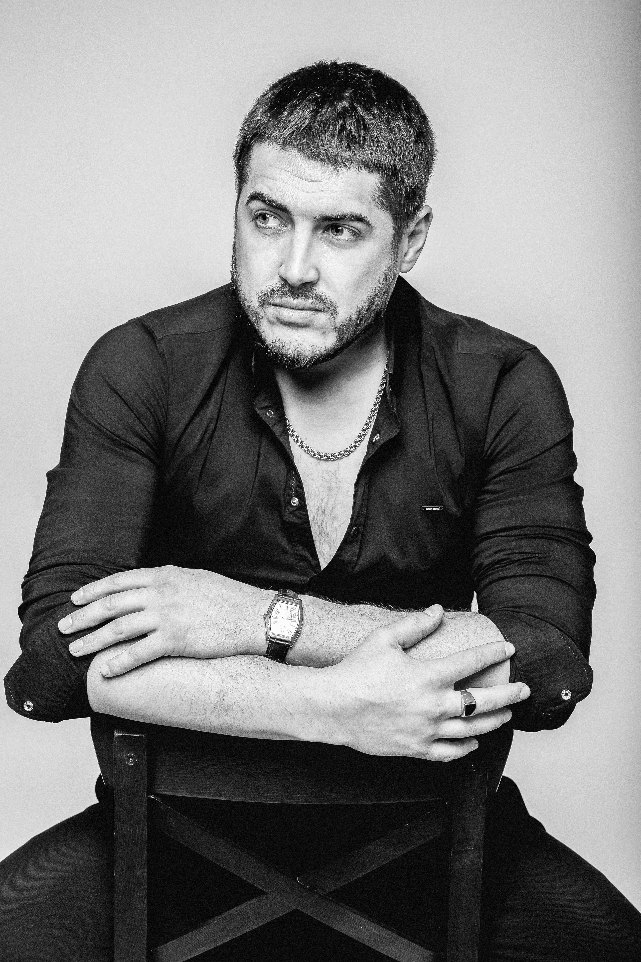 мужская модель сидит на стуле смотрит в даль