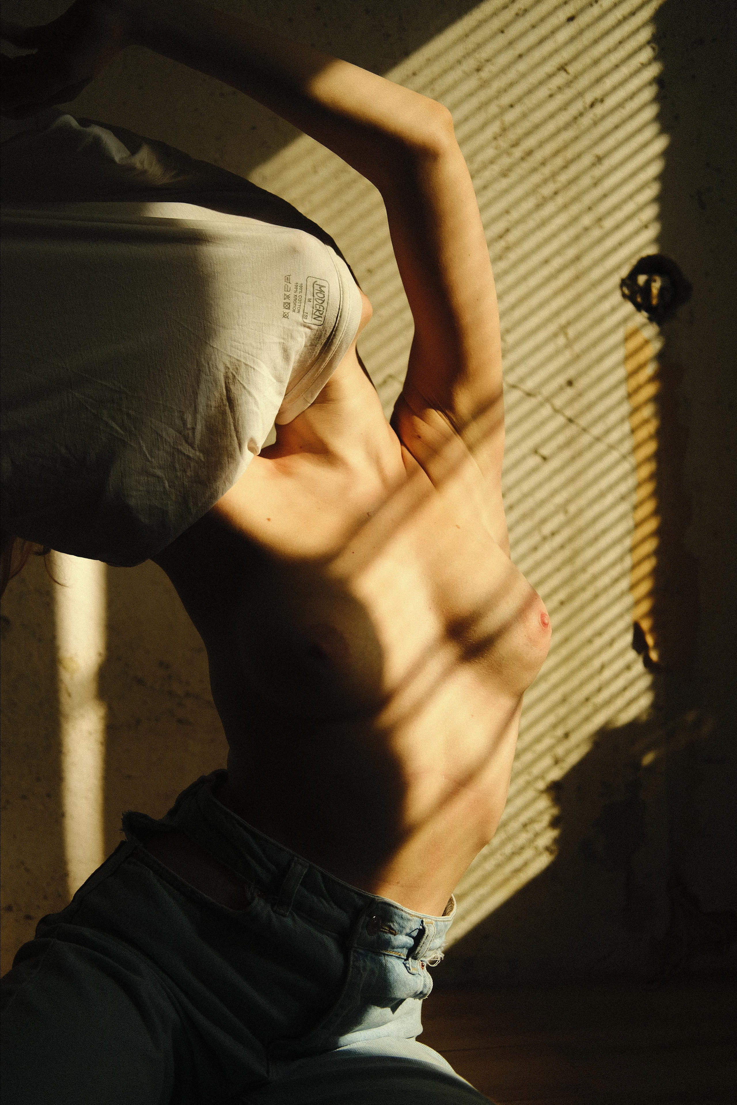 Девушка снимает футболку