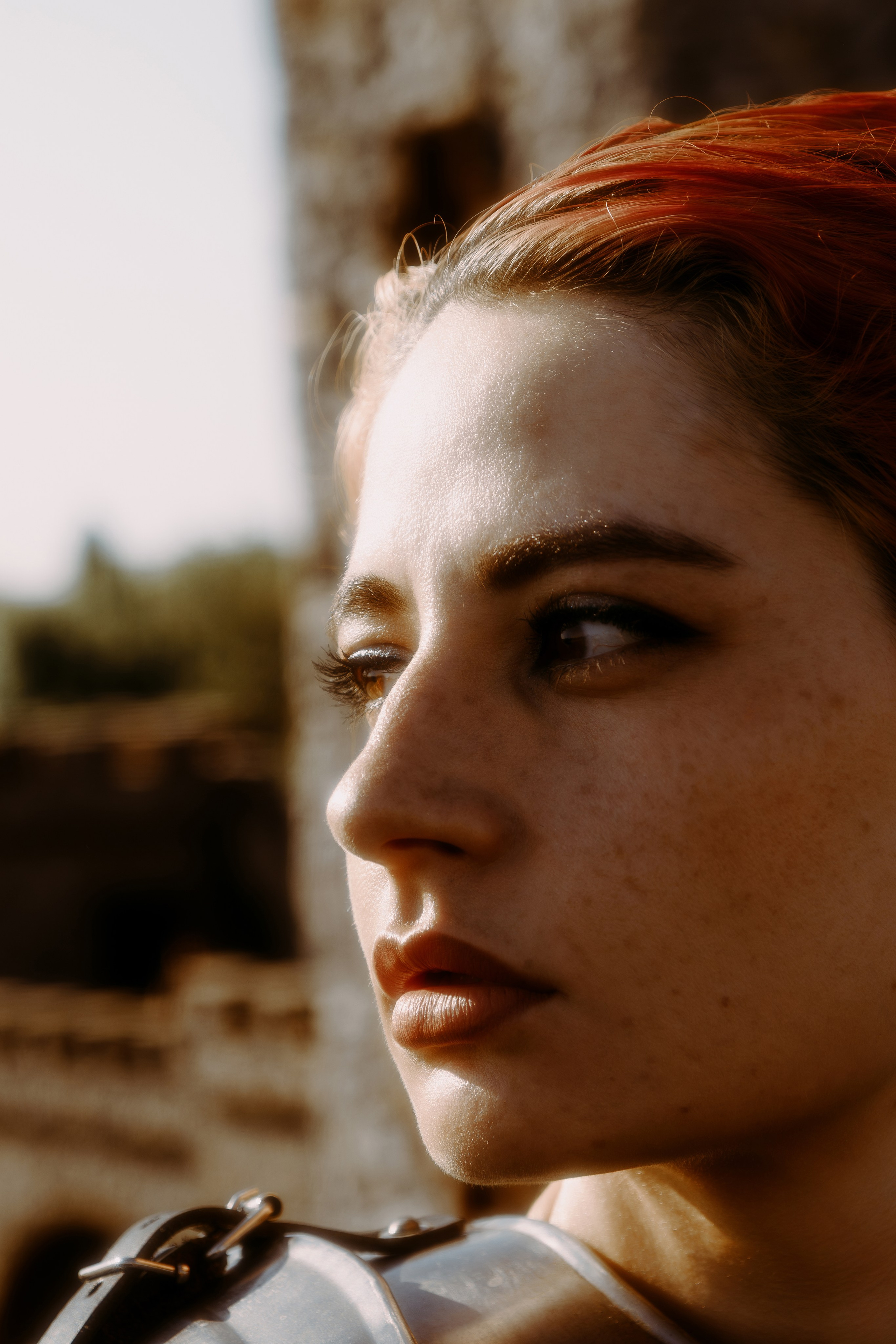 Очень красивый портрет девушки с короткими, красными волосам на фоне рыцарского замка