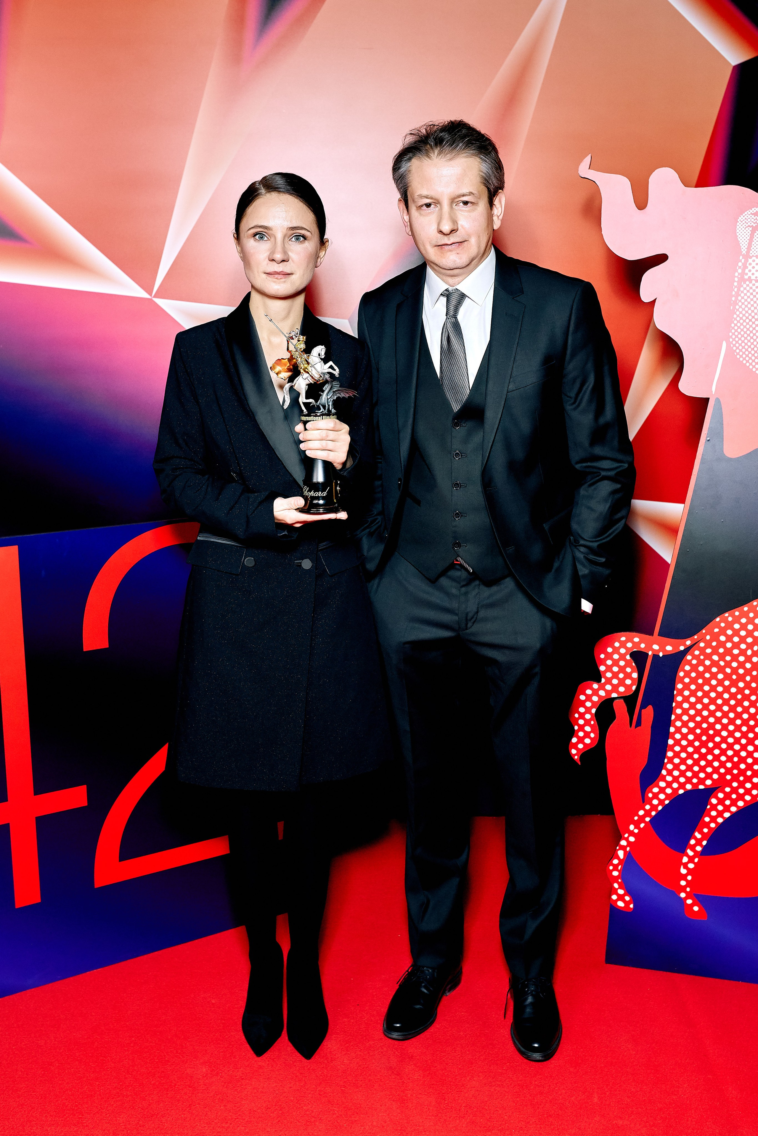 Репортажный фотограф сделал кадр на вручении награды МКФ - на фото мужчина и женщина одетые в деловом стиле