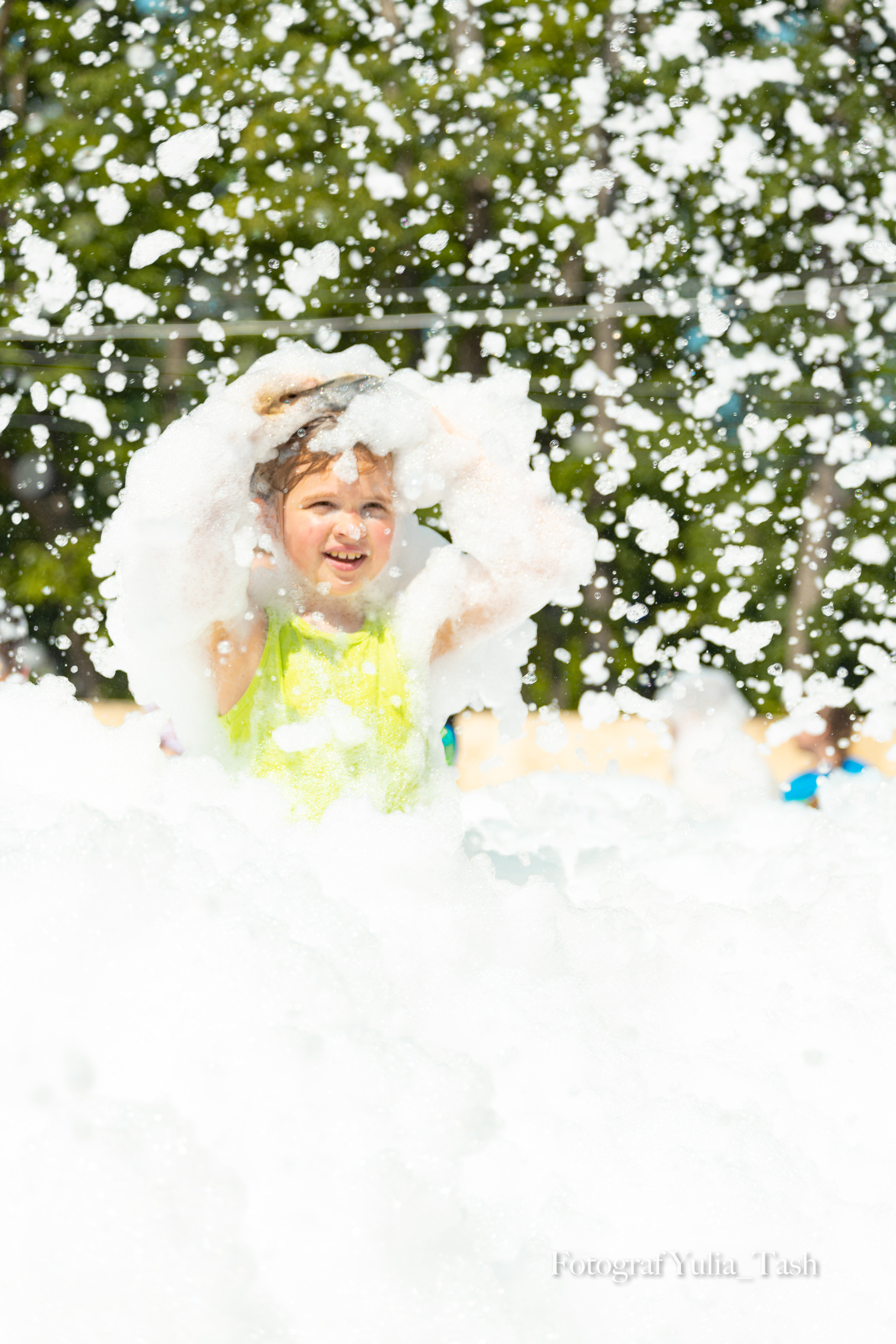 ребенок веселится в пене на празднике