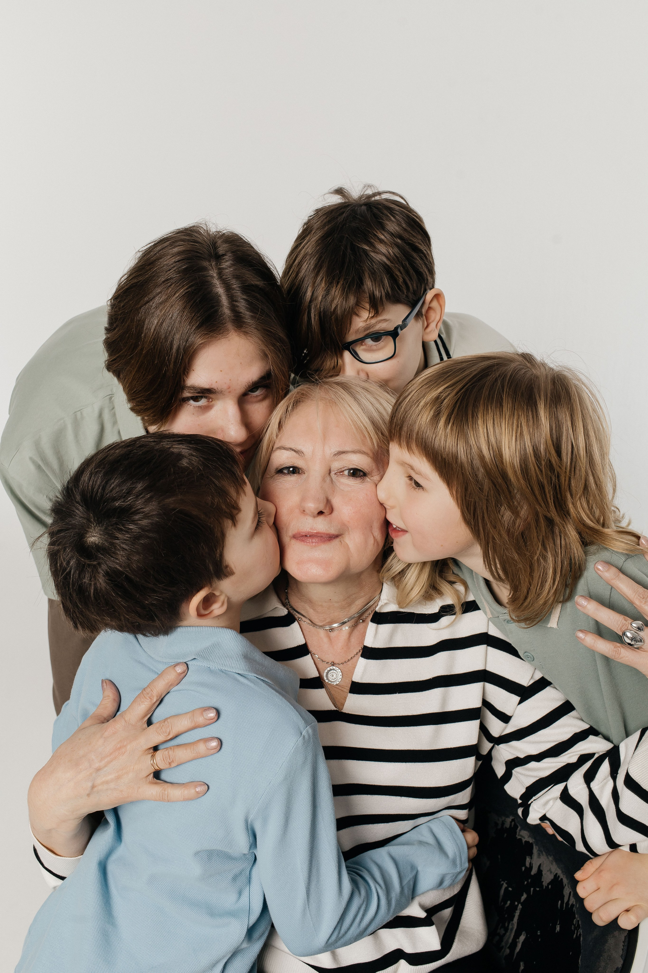 мама обнимает и целует сына, держа его на руках