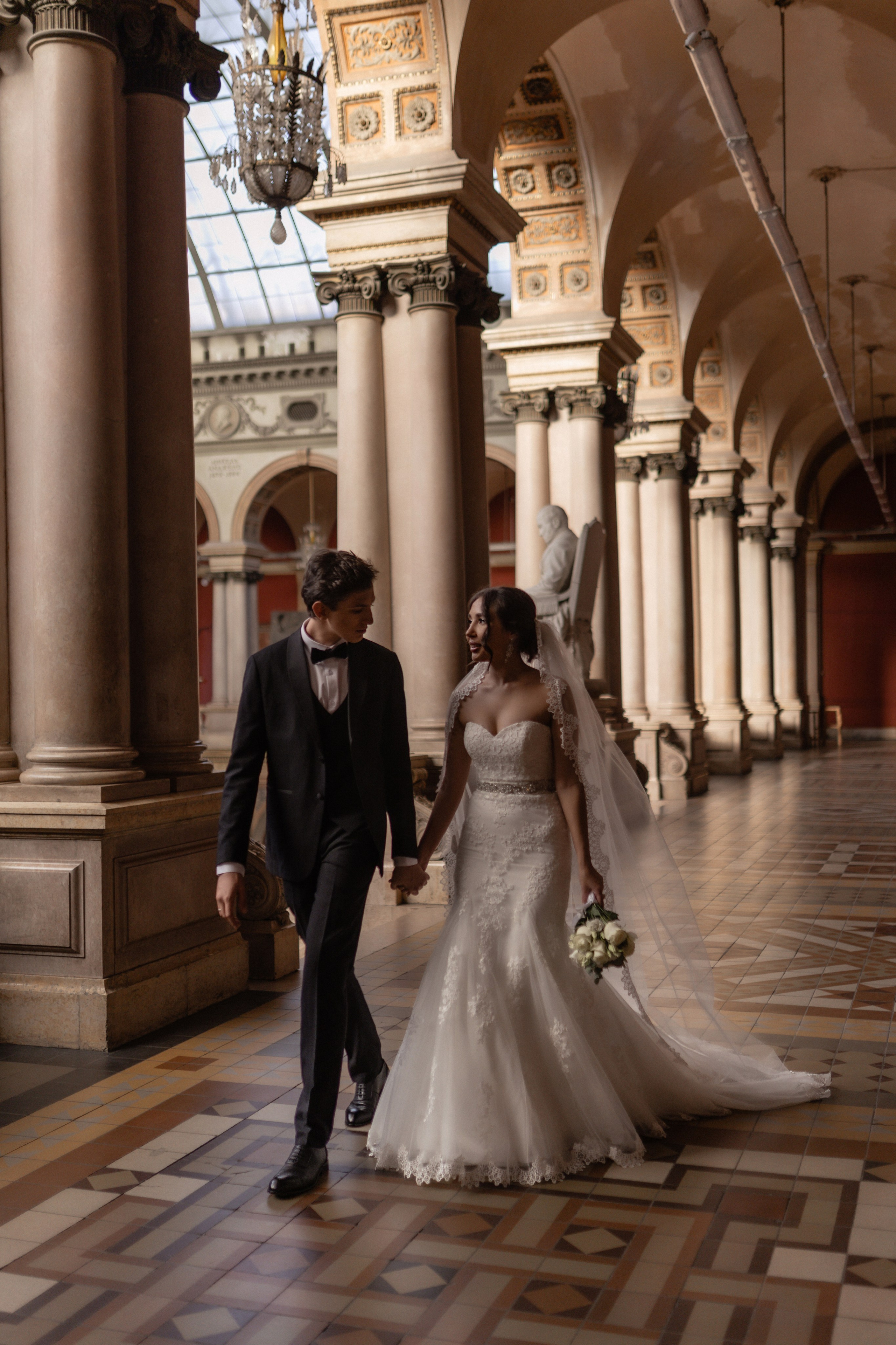 Невеста и жених стоят на фоне природы, нежно обнимаются и смотрят друг другу в глаза