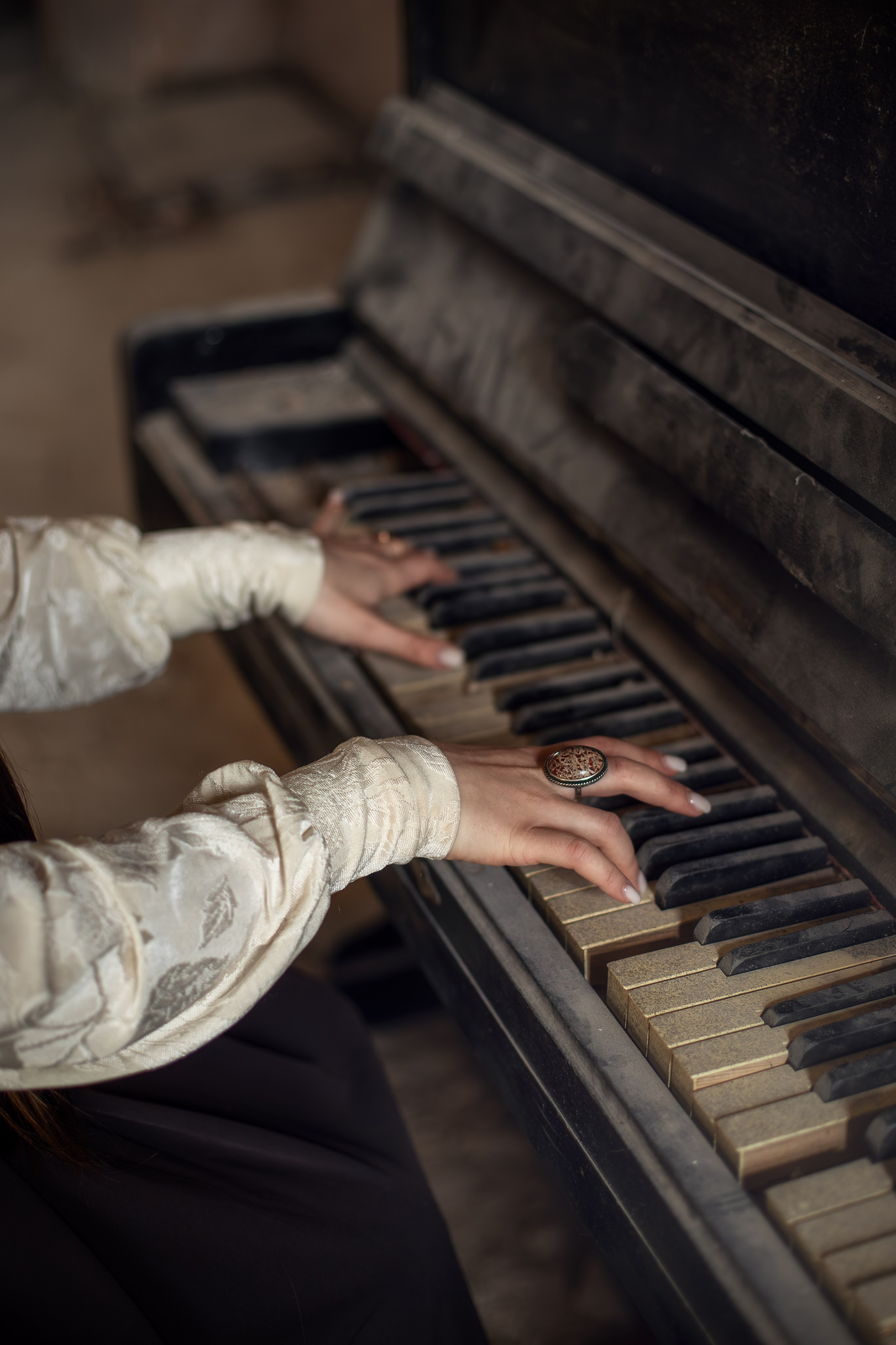 Руки девушки играют на старом пианино, крупный план клавиш и деталей, атмосферный свет и винтажная фактура.