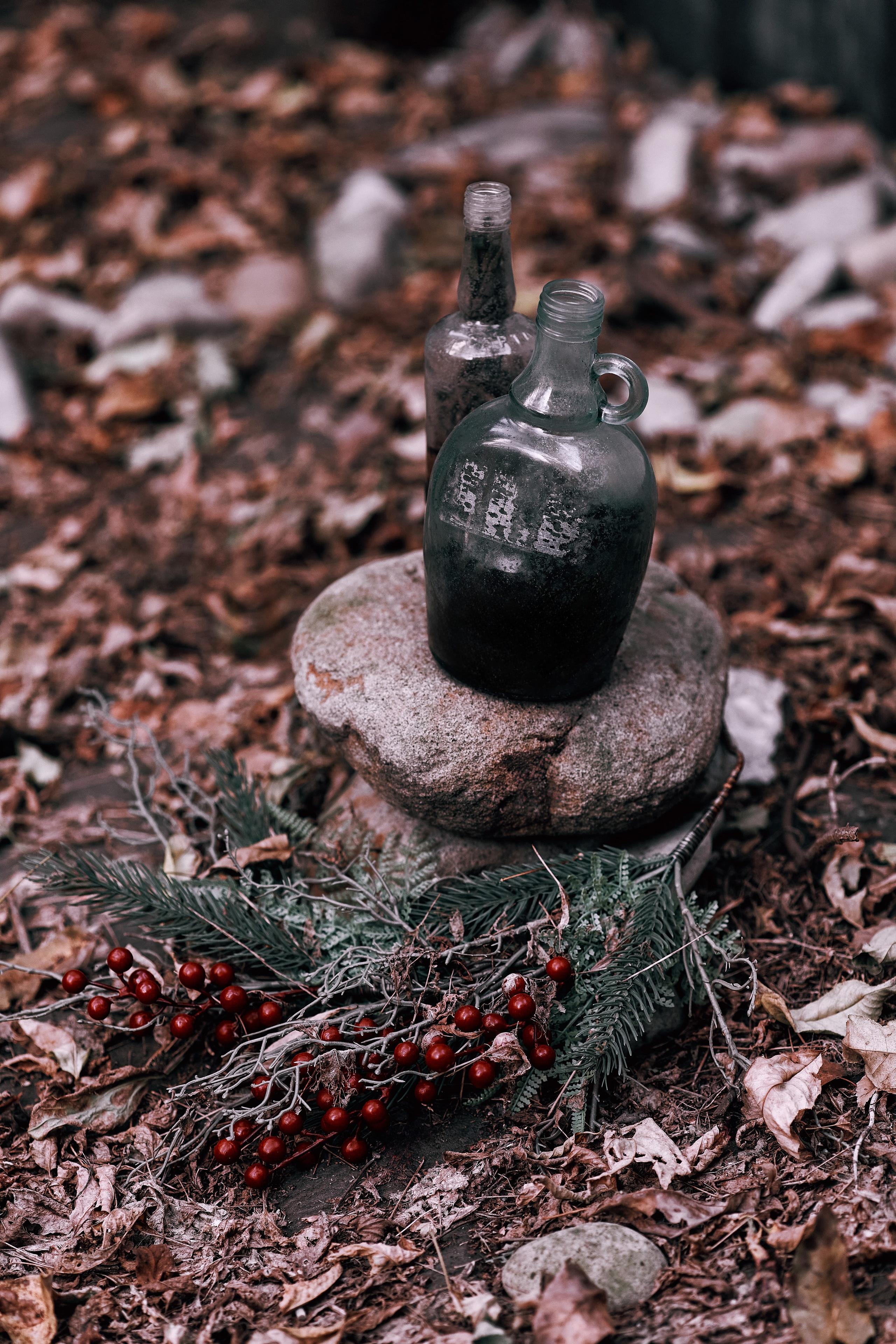 Бутылка с колдовским зельем и мрачными ягодами на фоне