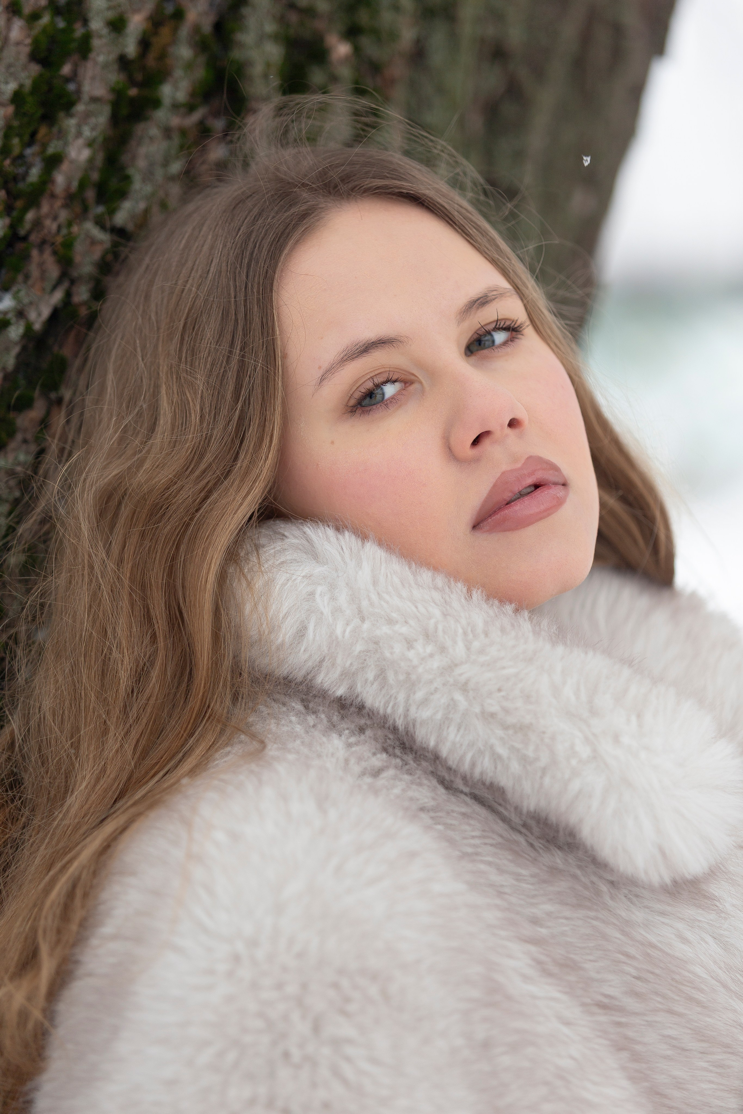 Крупный план девушке у дерева зимой в музее-заповеднике "Царицыно". Стрит фотосессия.