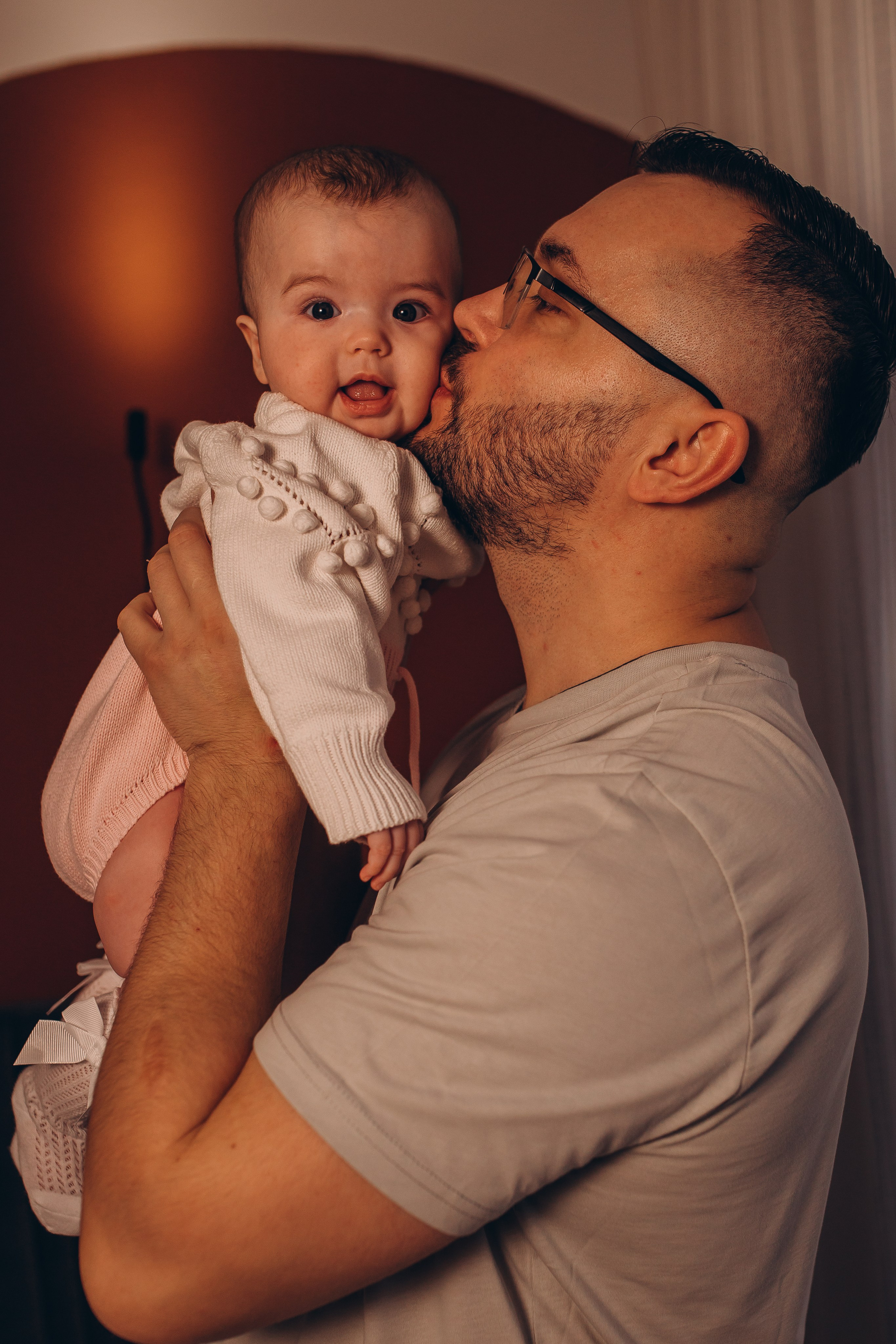 Счастливый улыбающийся младенец на руках у папы. Семейная фотосессия для малышей и новорожденных в Санкт-Петербурге, фотограф Маруся Самылкина.