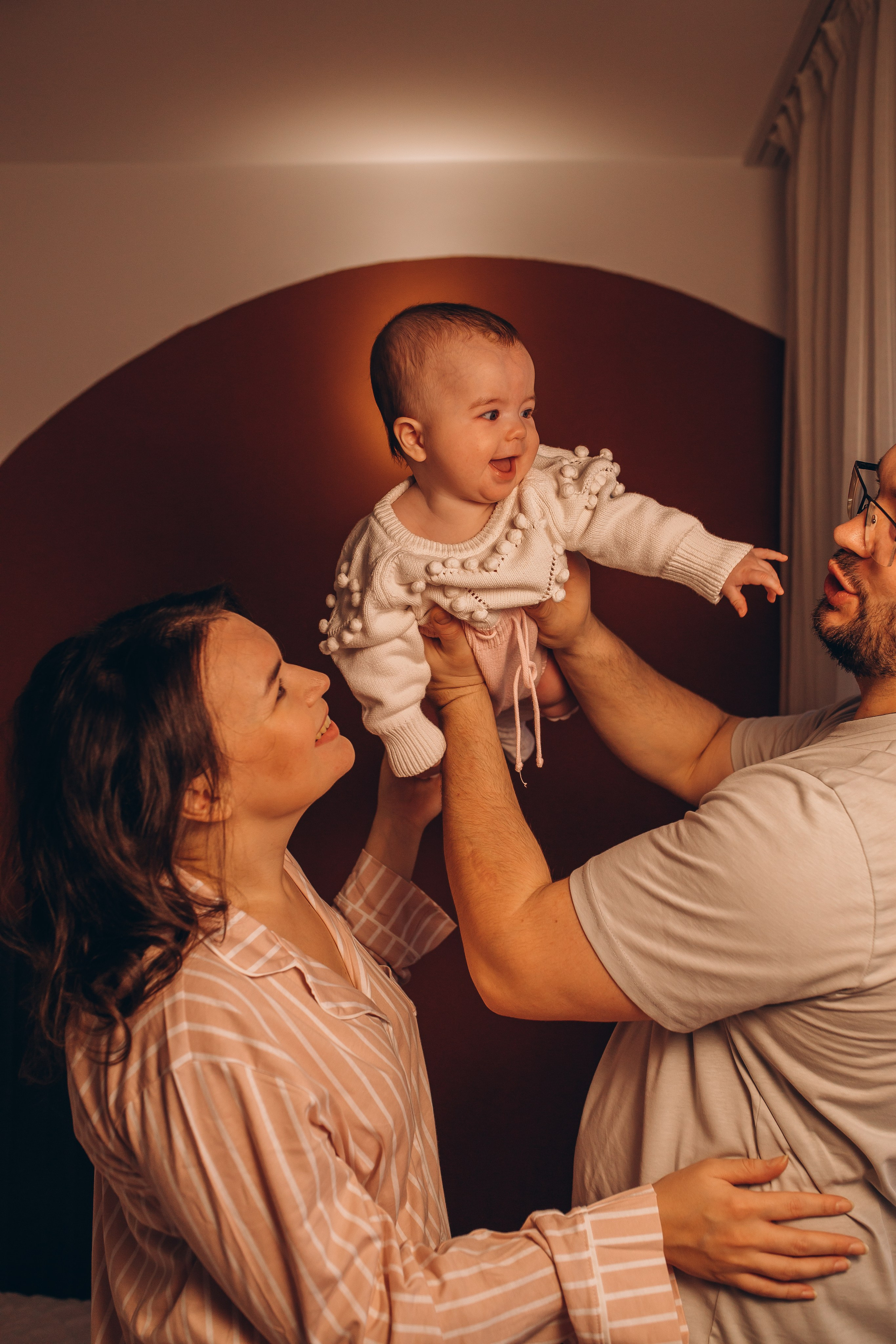 Мама целует счастливую улыбающуюся малышку в щеку. Фотосессия для малышей и новорожденных в Санкт-Петербурге, фотограф Маруся Самылкина.