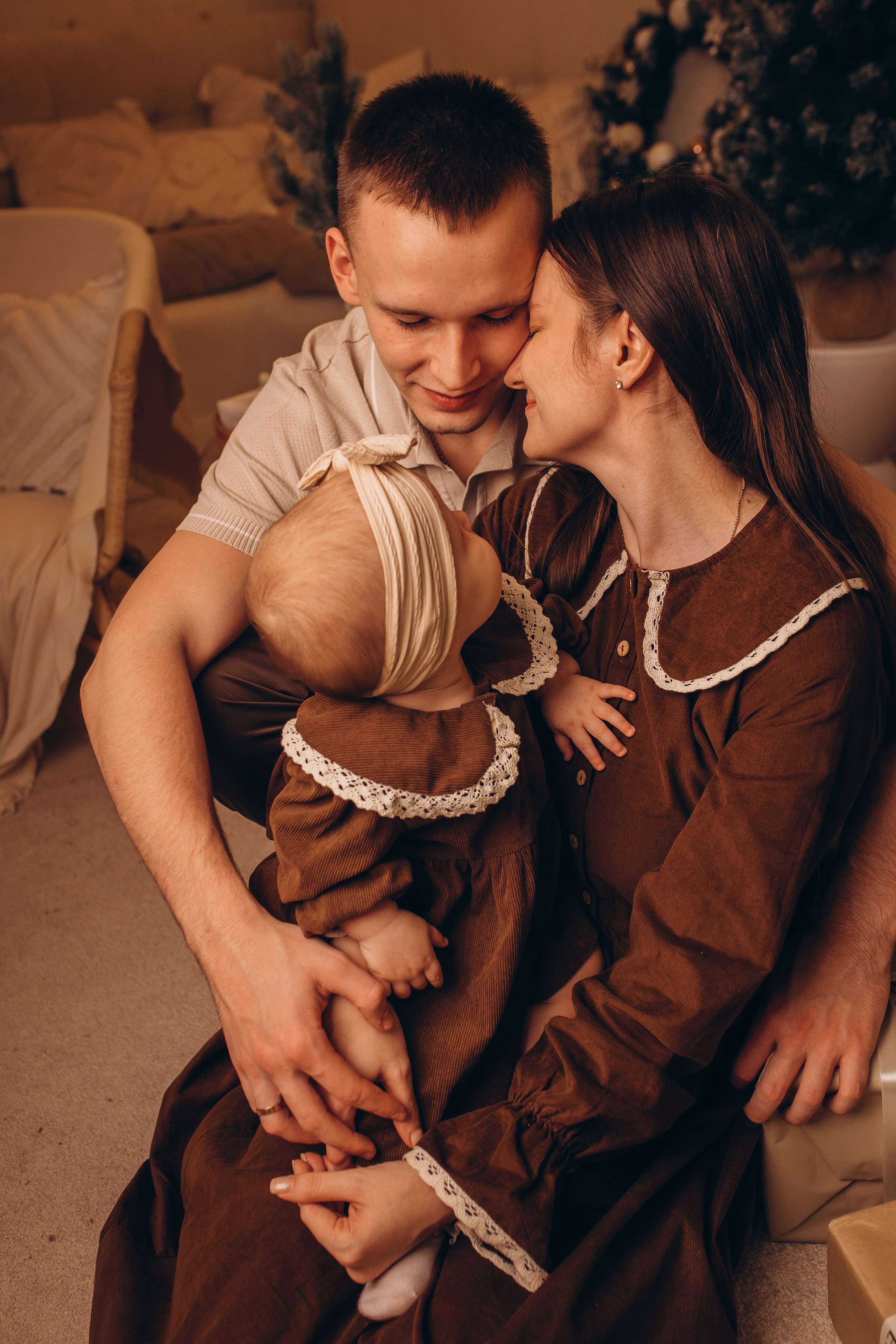 Ребёнок позирует на детской машине на фоне ёлки в новогоднем интерьере. Детский и семейный праздничный фотограф Маруся Самылкина в Санкт-Петербурге.