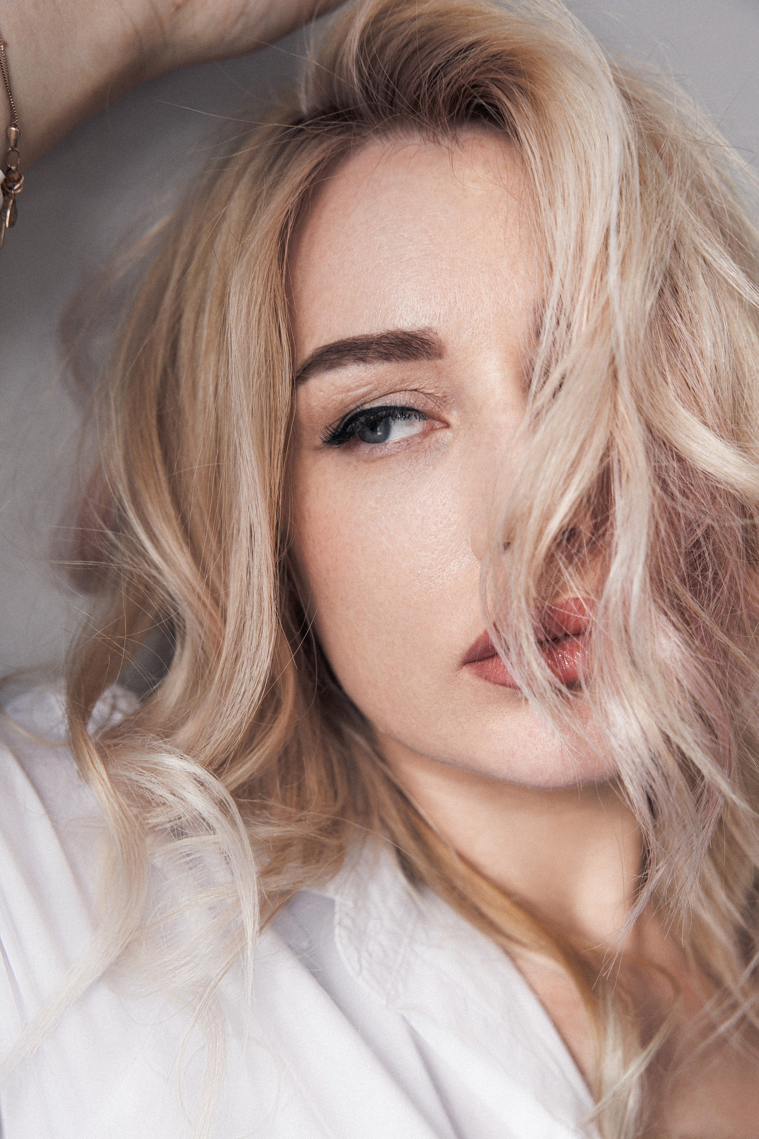 девушка поправляет прическу  с красными губами