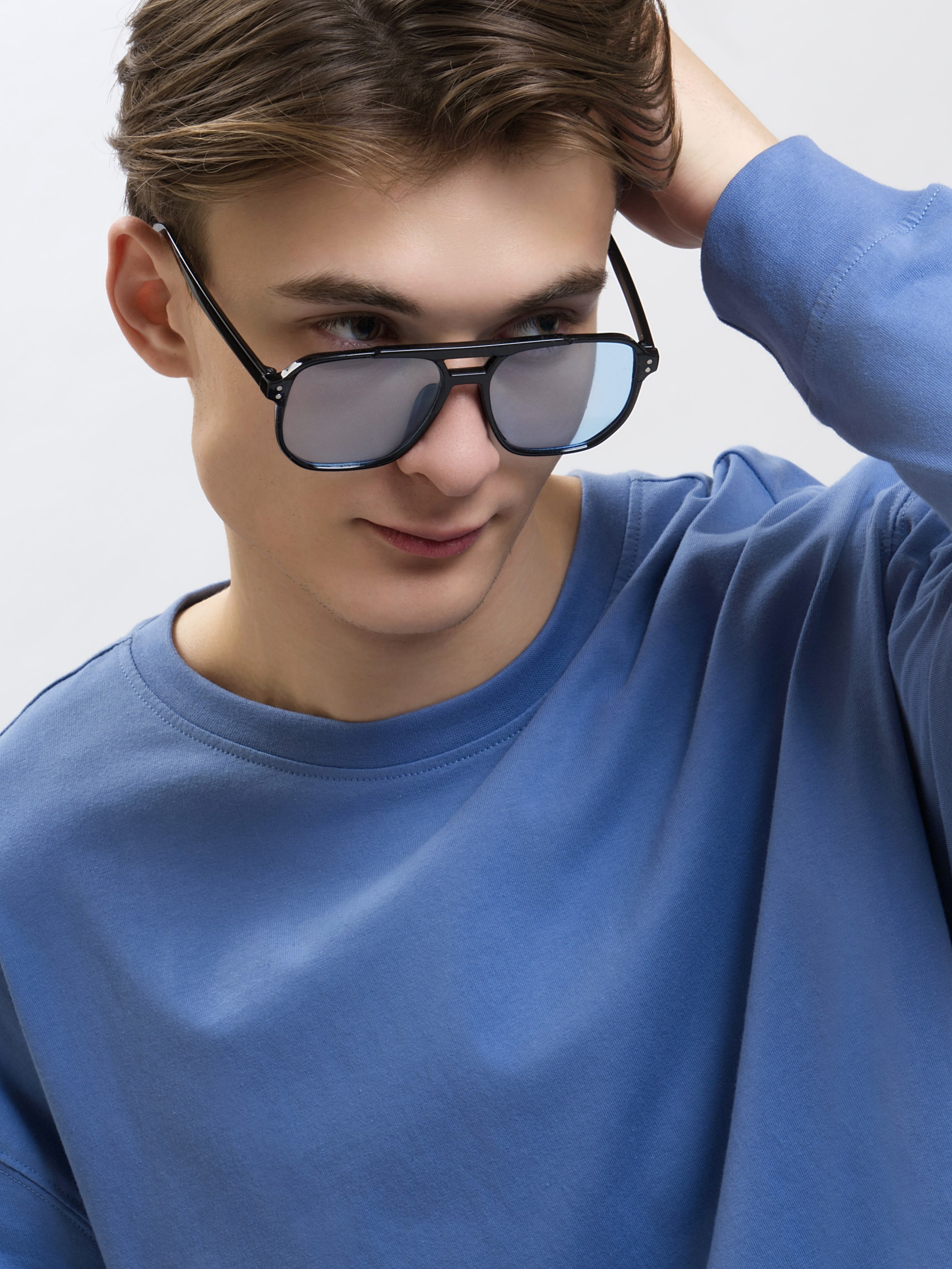 Модель в солнечных очках с темными линзами на белом фоне - фото для маркетплейсов.