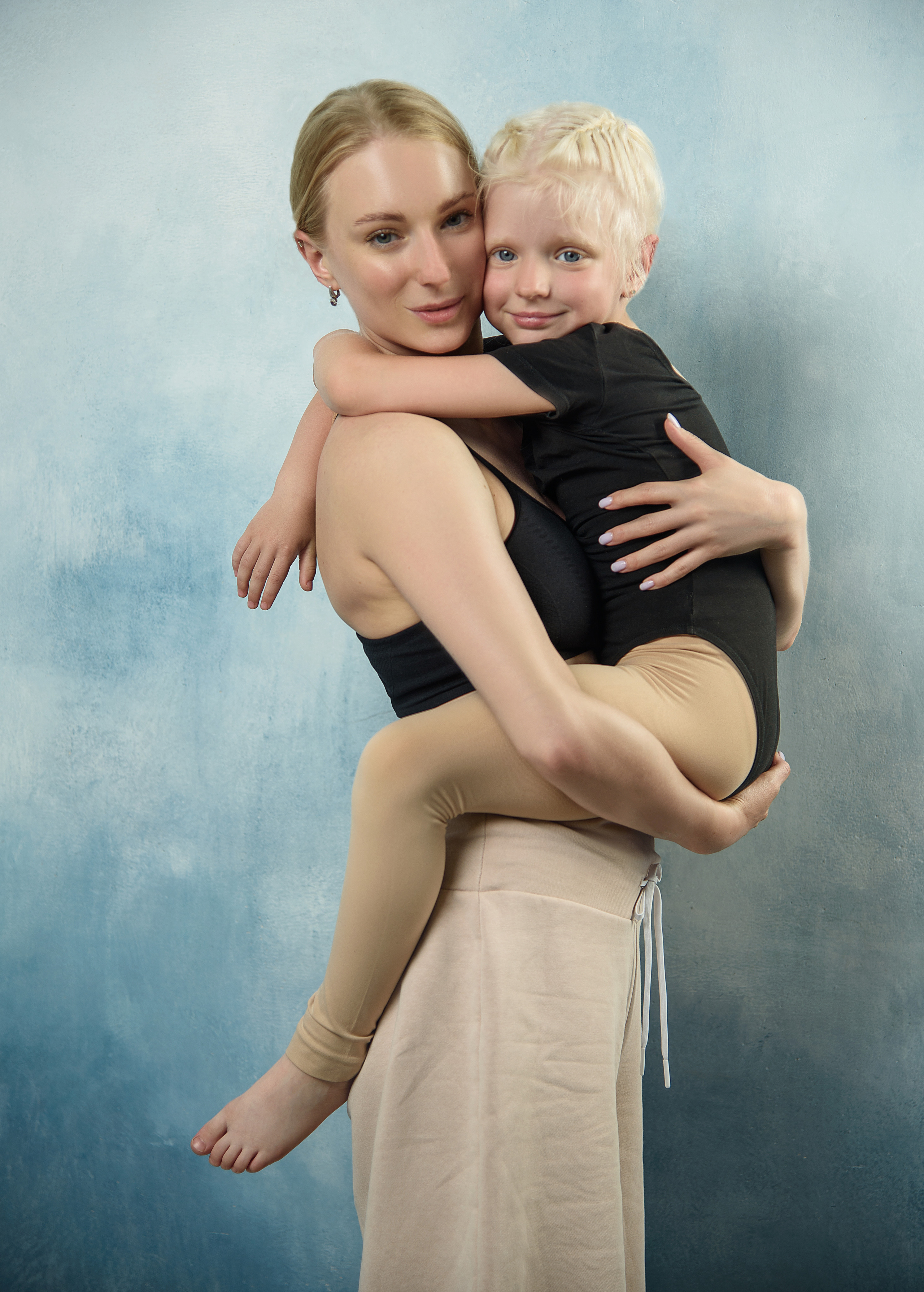 мама и дочь в танцевальной одежде на голубом фоне дочь нежно обнимает маму