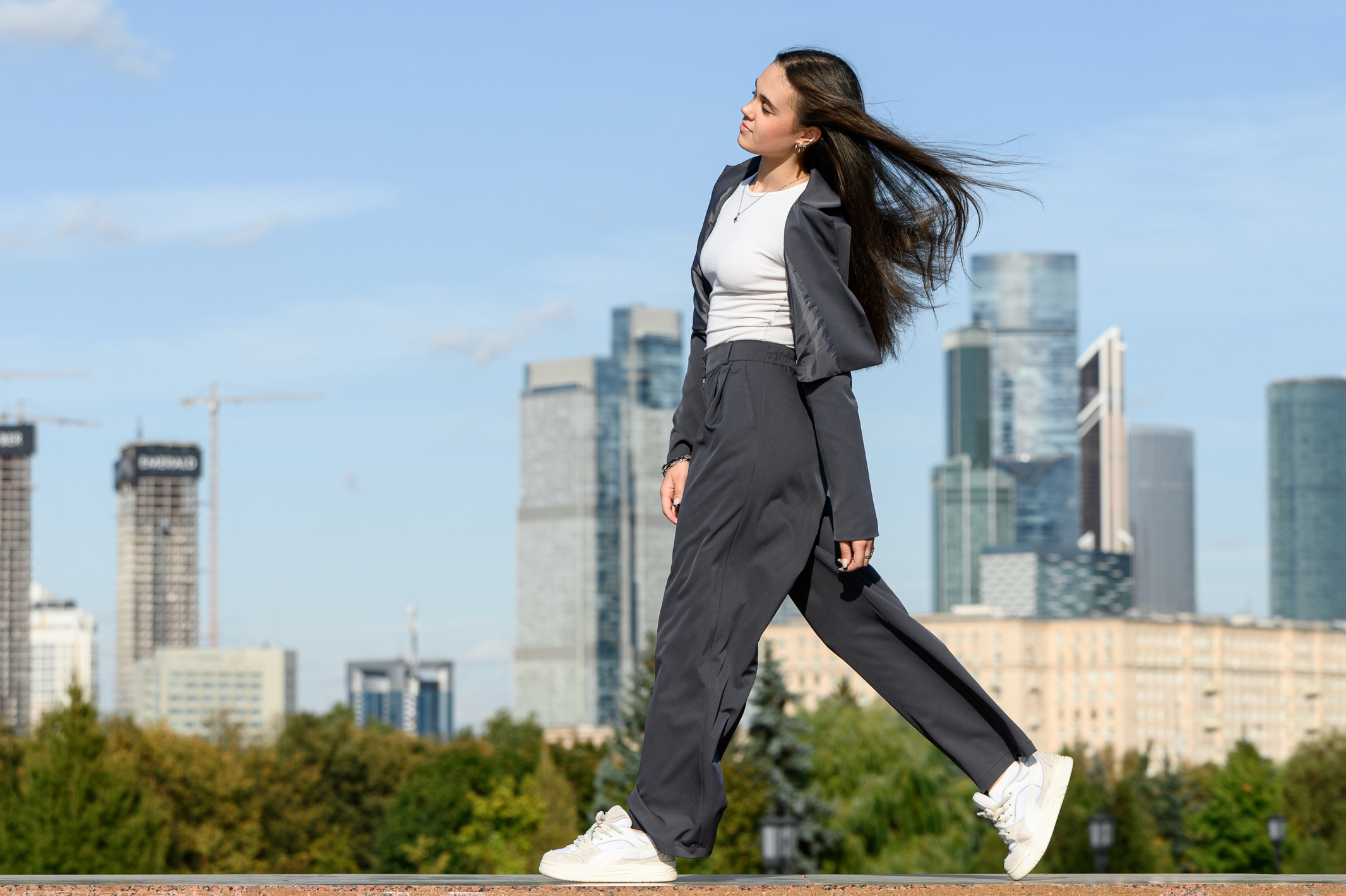 Старшеклассница идёт на фоне небоскрёбов.