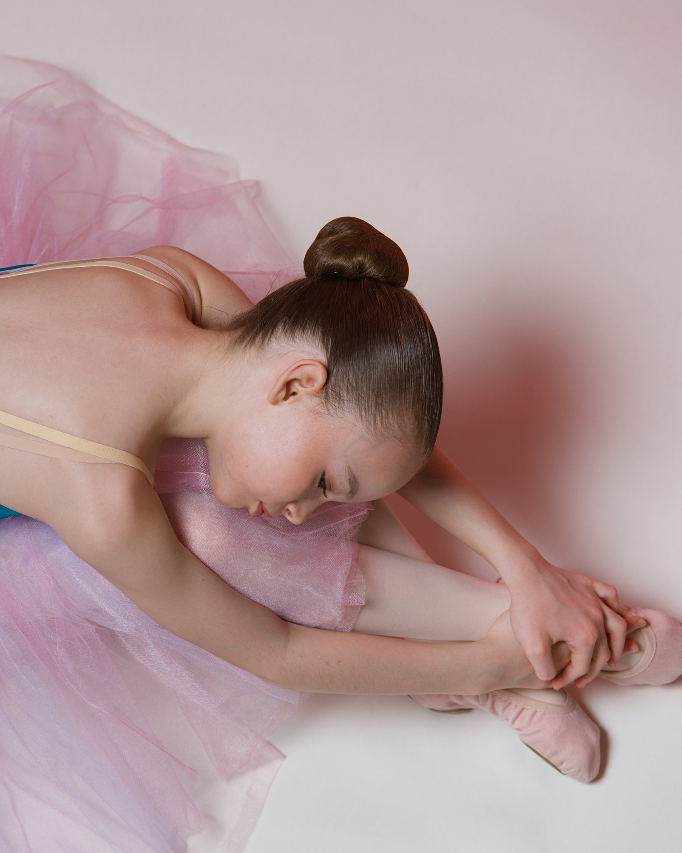 Эстетика балета для детей: девочка-балерина в изящной позе. Фотосъемка классического танца в светлой студии Тюмени от спортивного фотографа.