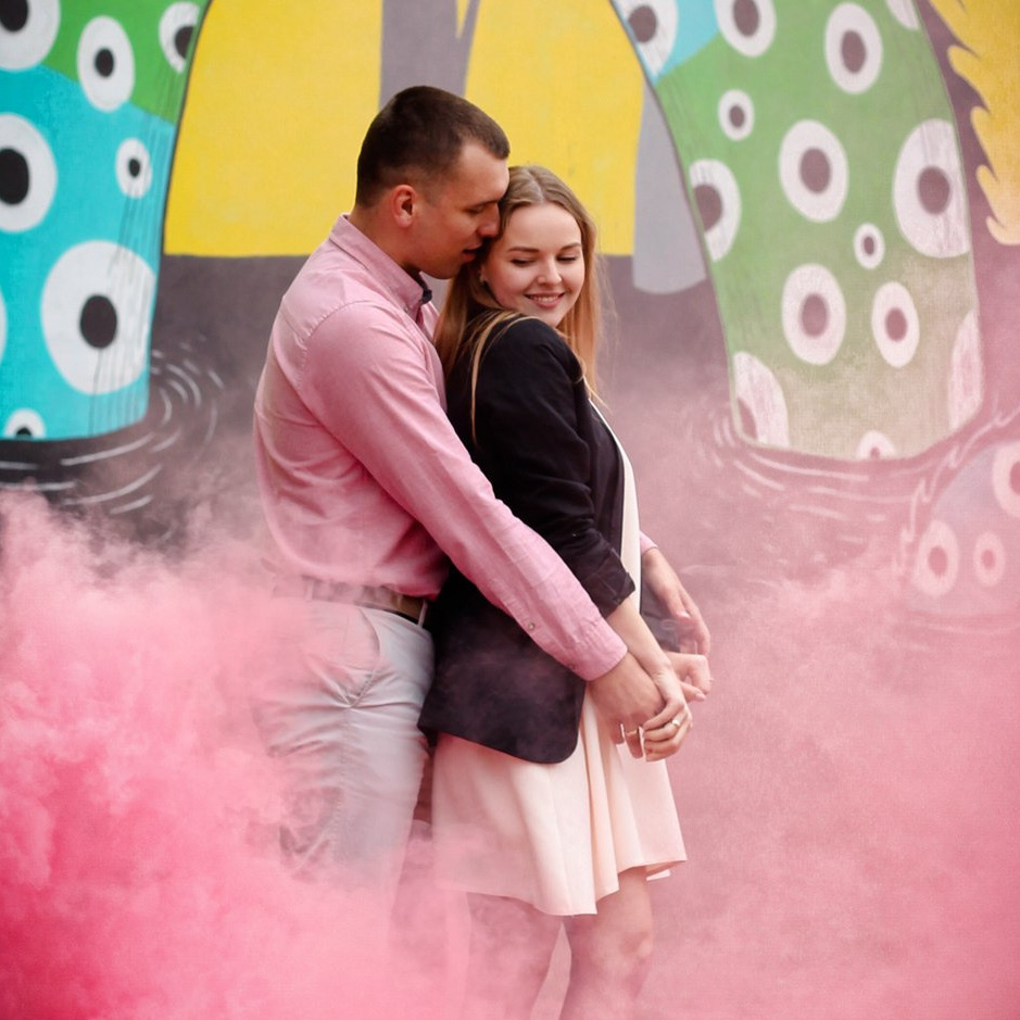 молодая пара обнимаются в розовом дыму