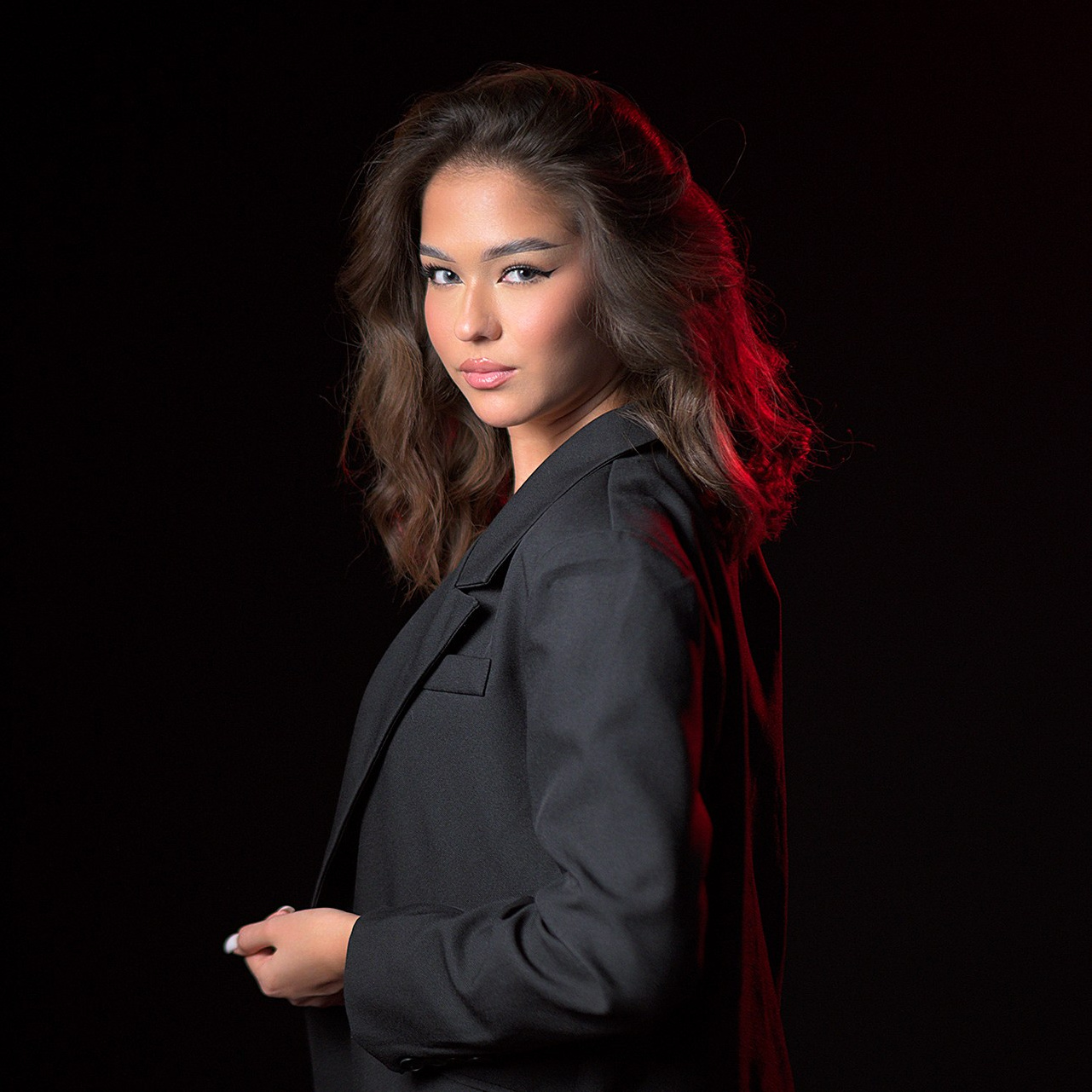 Девушка позирует на черном фоне в фотостудии в Караганда