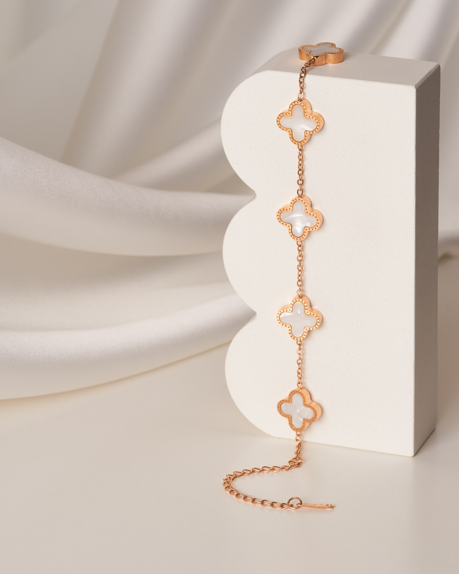 Браслет с клеверами свисает с бетонной подставки