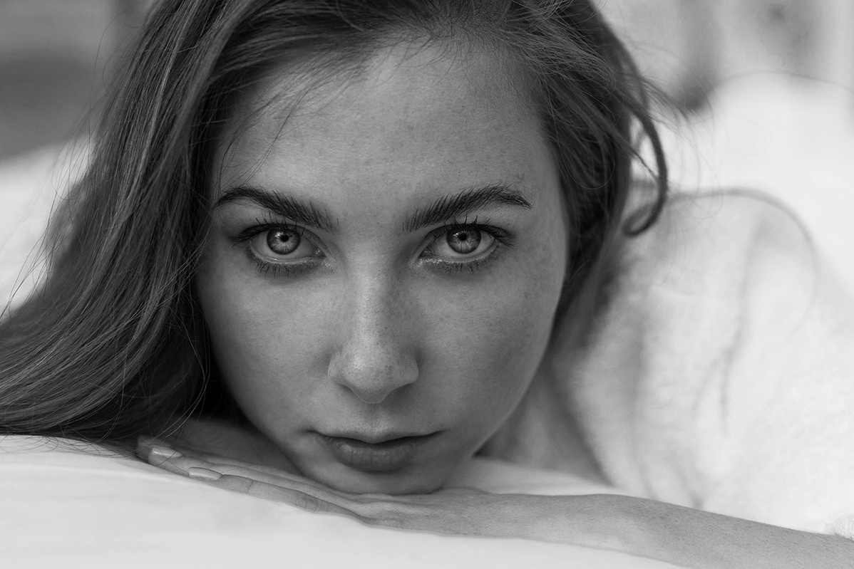 девушка с веснушками в белом халате оперлась подбородком о свою руку