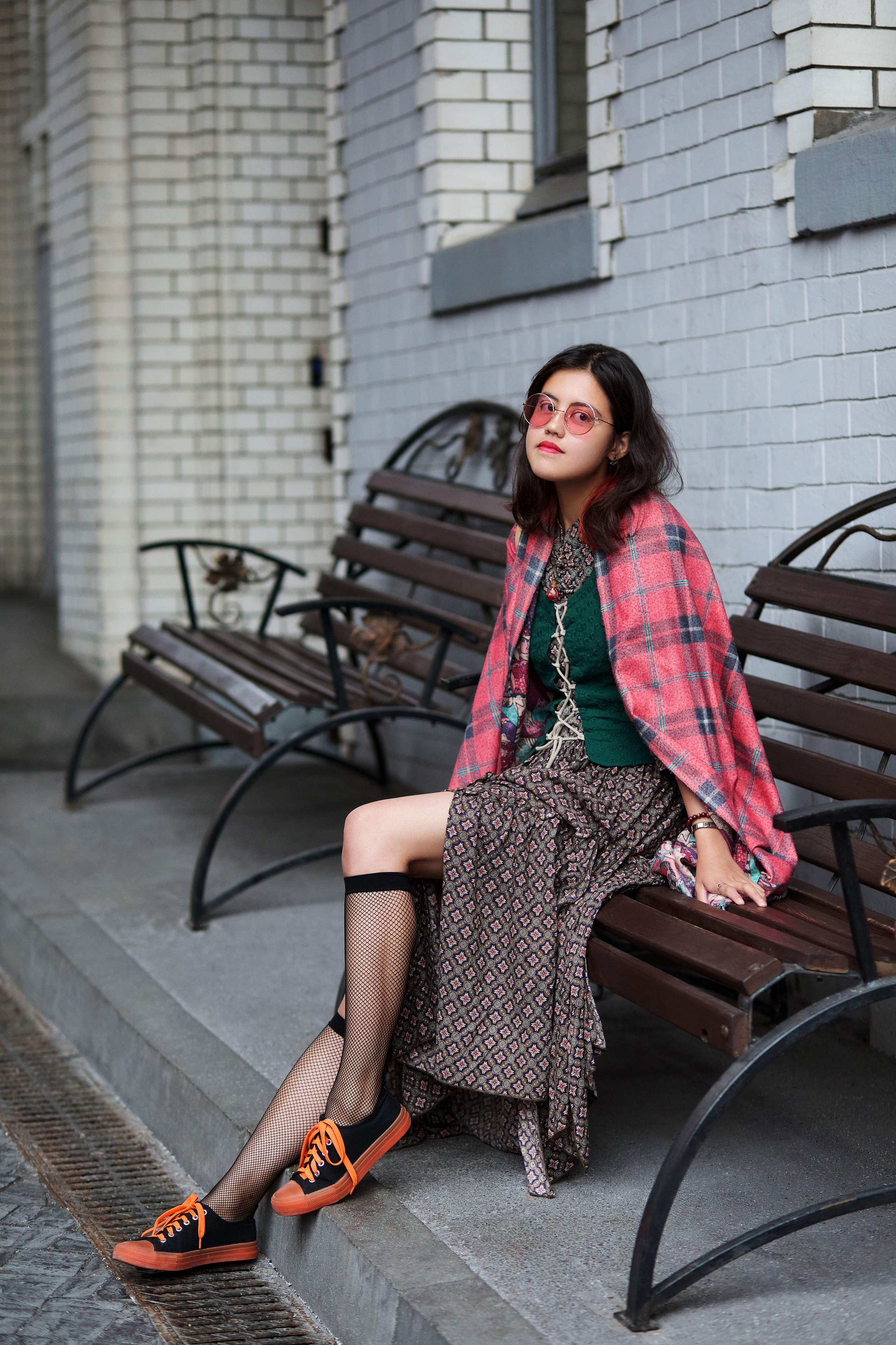 Фотосессия с девушкой в чулках и ярких кроссовках, позирующей на лавочке в городе Владивостоке