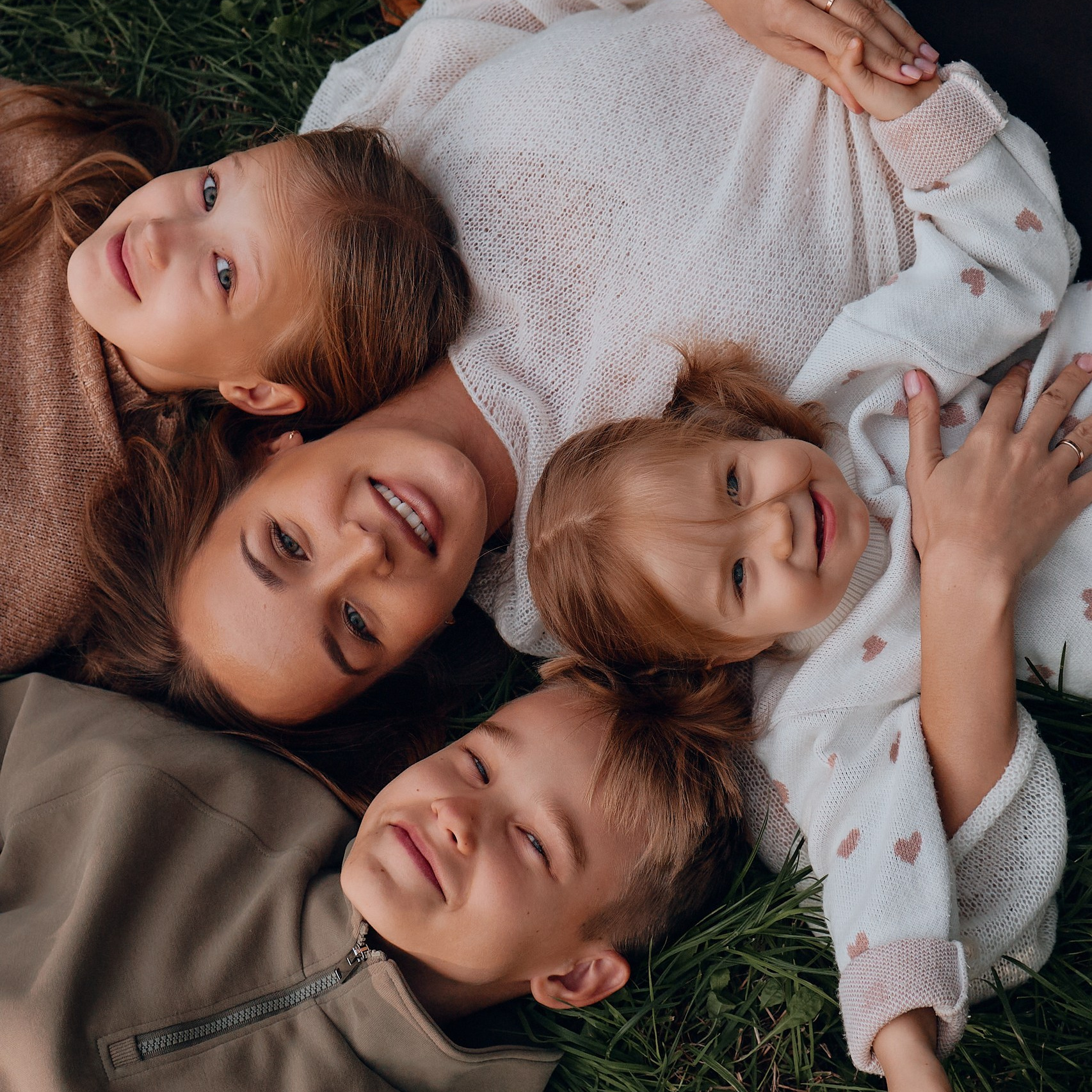 Семейный портрет: родители, одетые в черное, с любовью целуют свою маленькую дочку, которая держит в руках украшение.