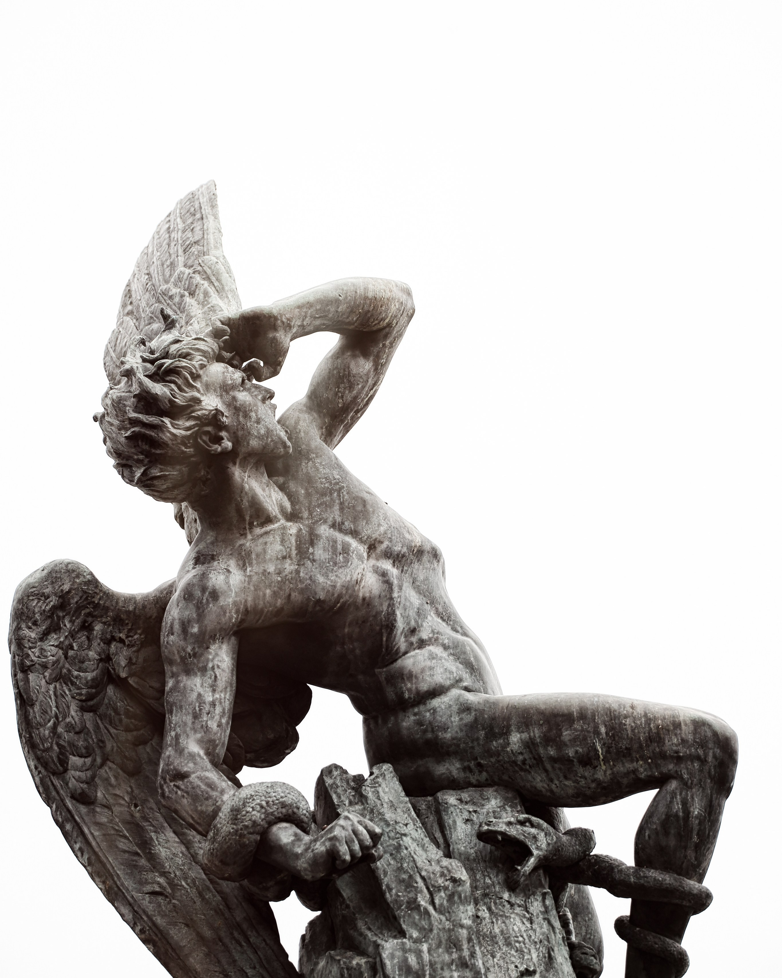 Скульптура ангела с распростертыми крыльями в динамичной позе, каменная резьба, черно-белое фото мемориальной скульптуры