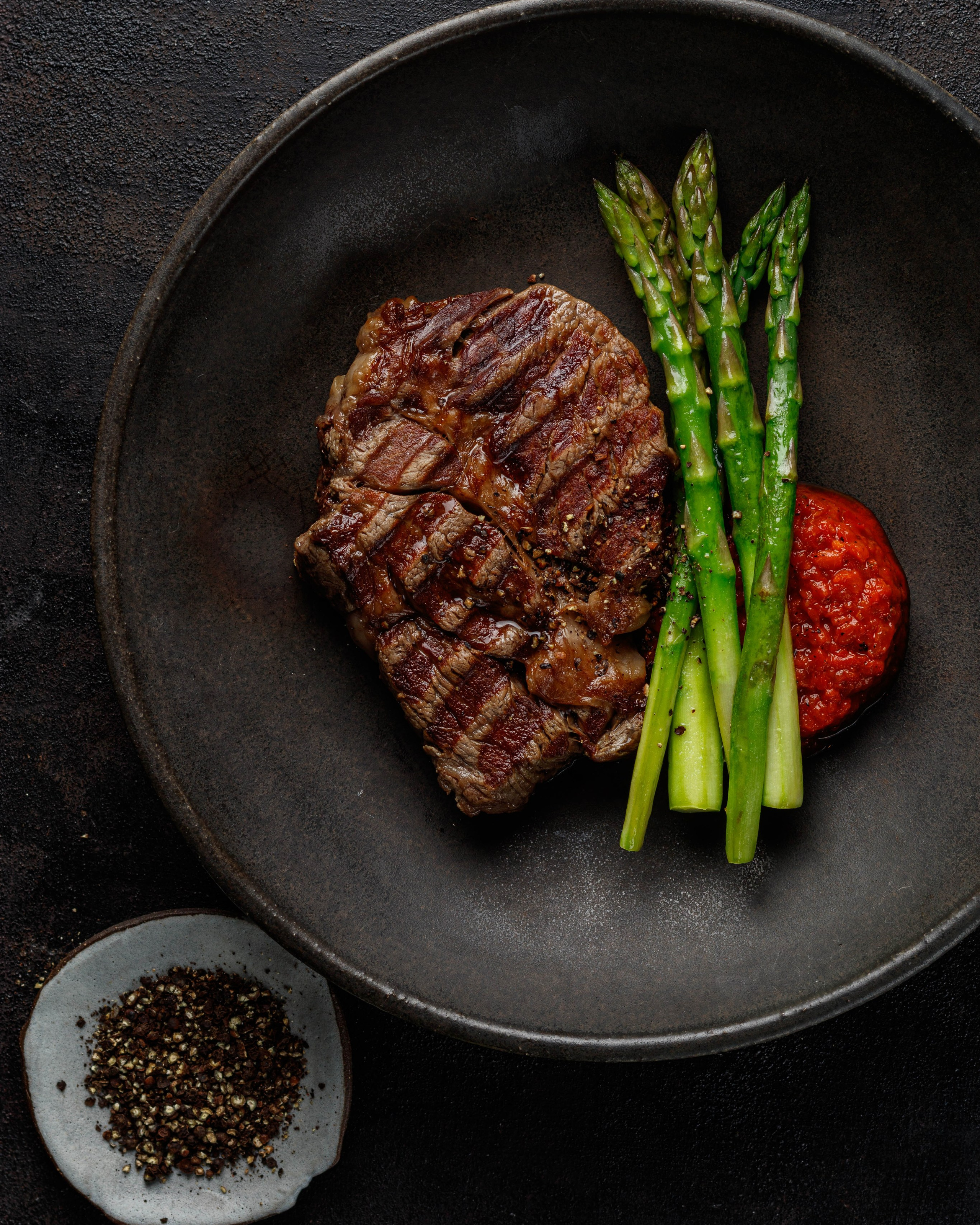 Свежий салат с сыром с голубой плесенью и свеклой, сервированный на тарелке с салфеткой и соусником.