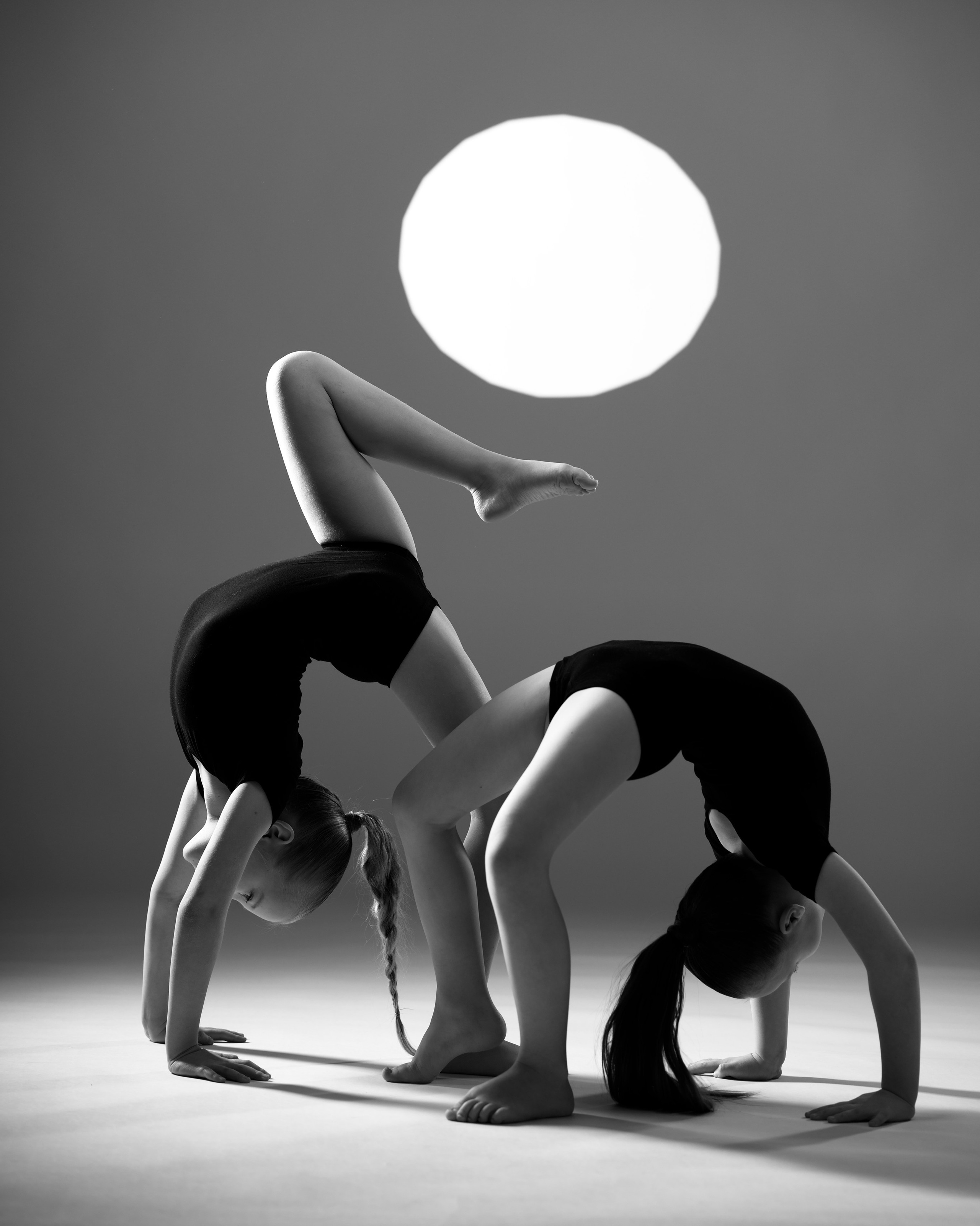 Художественная гимнастка в гибкой позе с мячом, зеркальное отражение и цветной свет в стиле спортарт