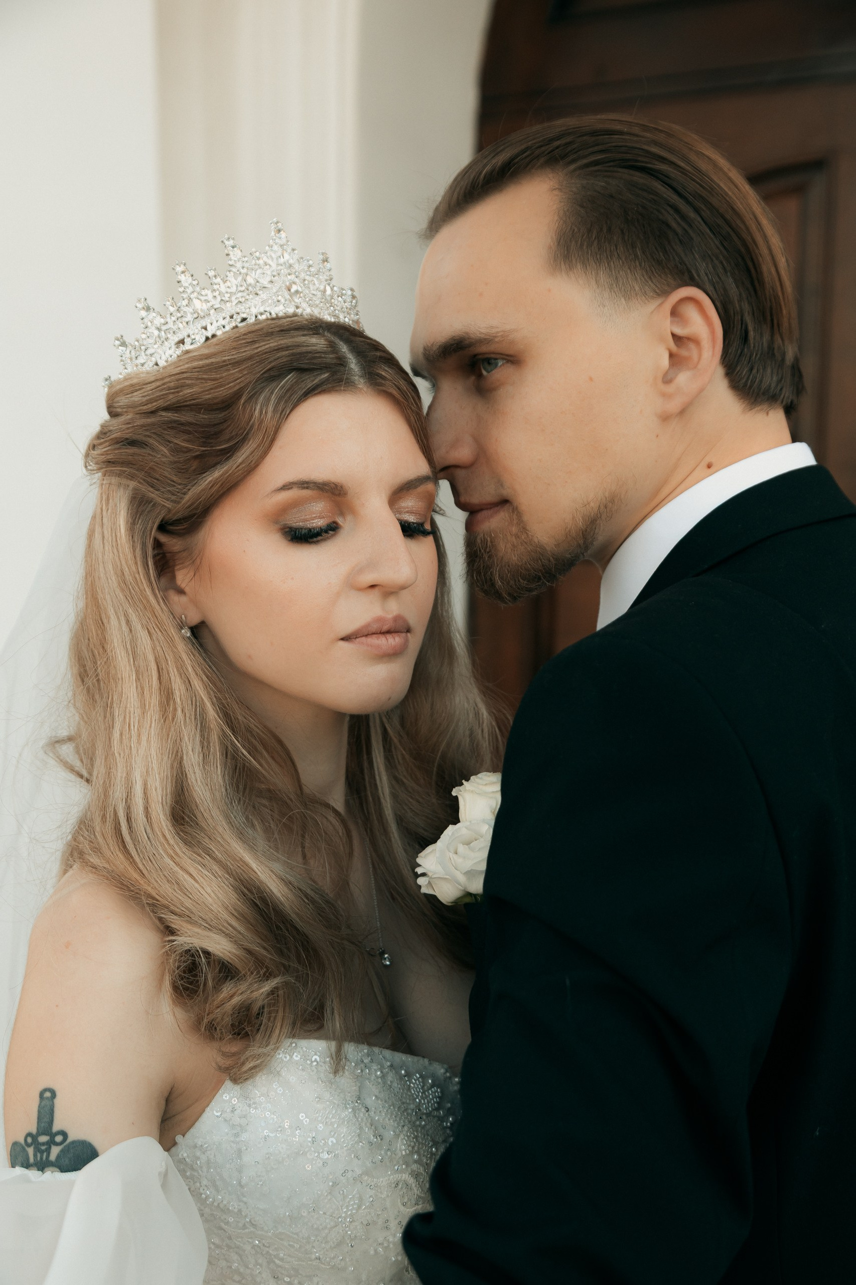 Невеста и жених в портрете, жених целует висок невесты.