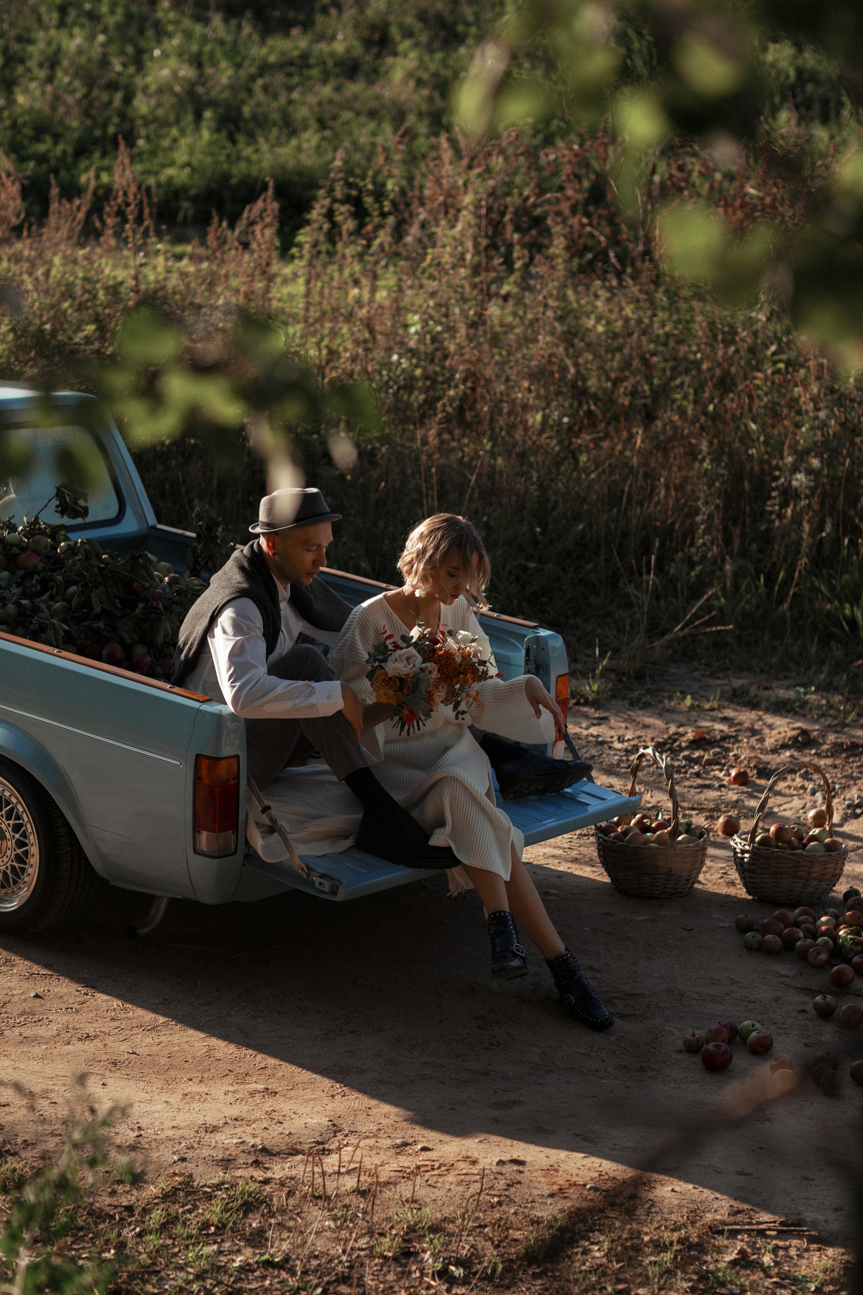 Молодожены сидят в кузове машины нежно смотря друг на друга