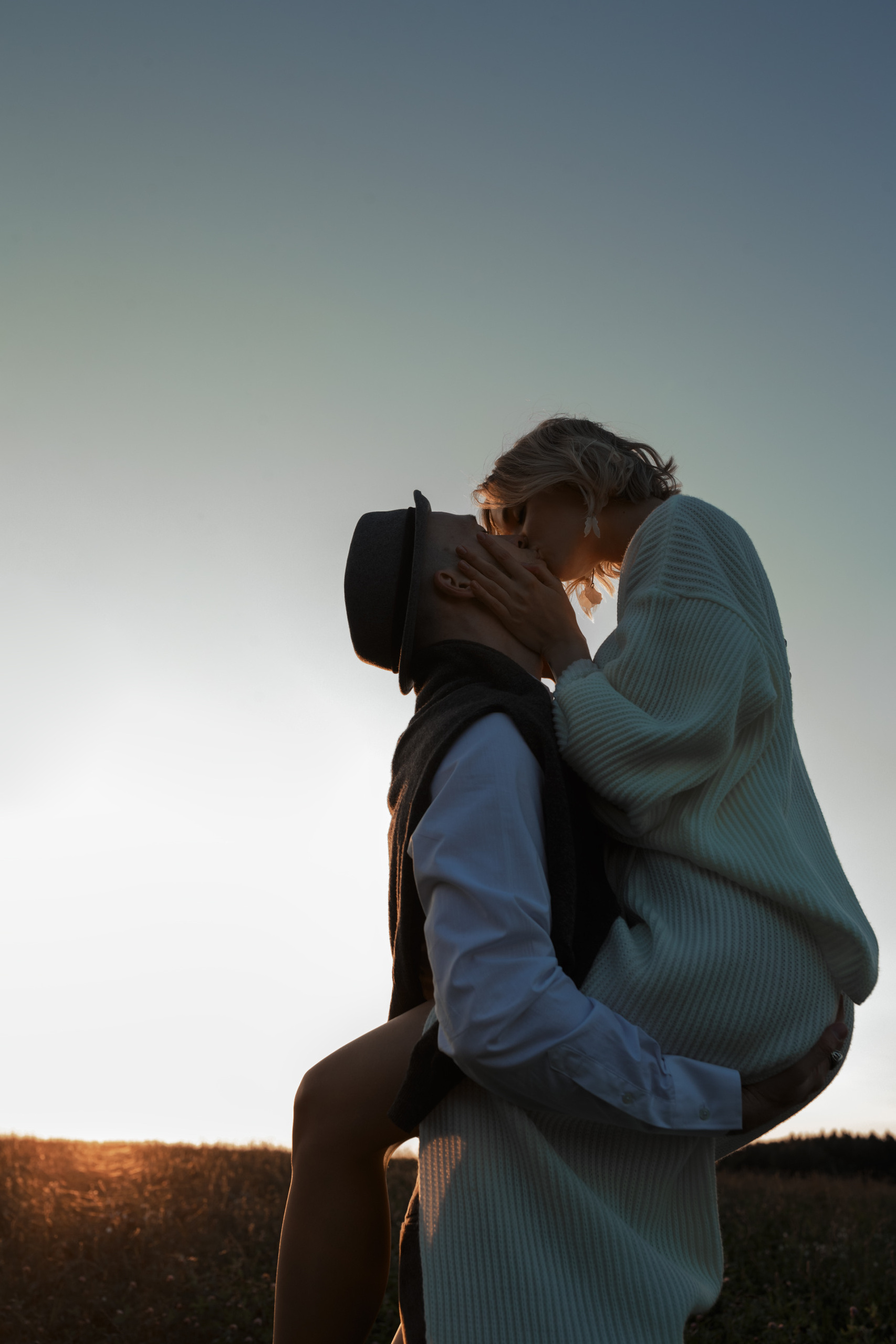 Невеста запрыгнула на жениха и поцеловать его. Жених и невеста кружатся в страстном  танце.