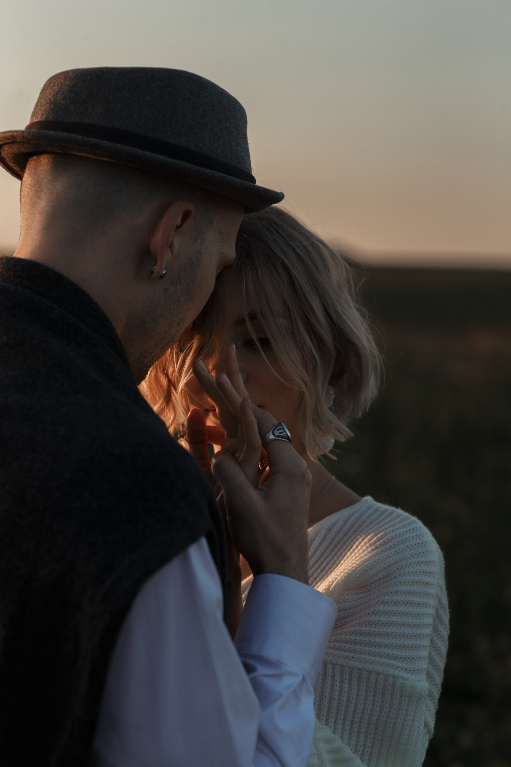 Невеста держит свои руки в руках жениха. Прислонилась своим лбом к его щеке.