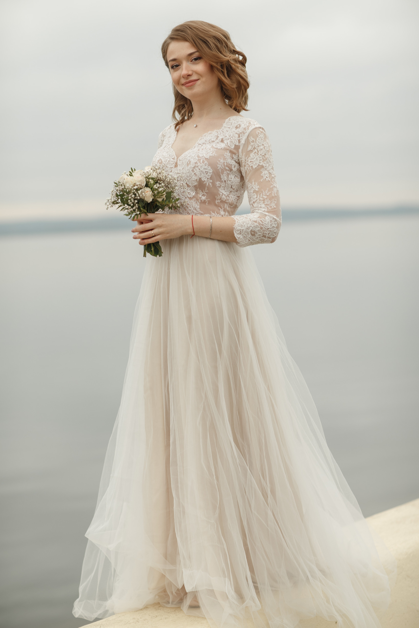 Свадебная прогулка красивой пары на берегу озера