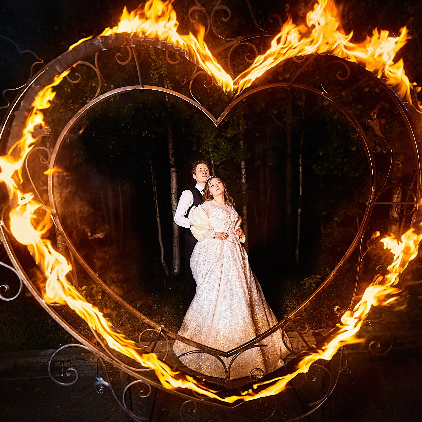 жених и невеста обнимаются внутри настоящего горящего сердца