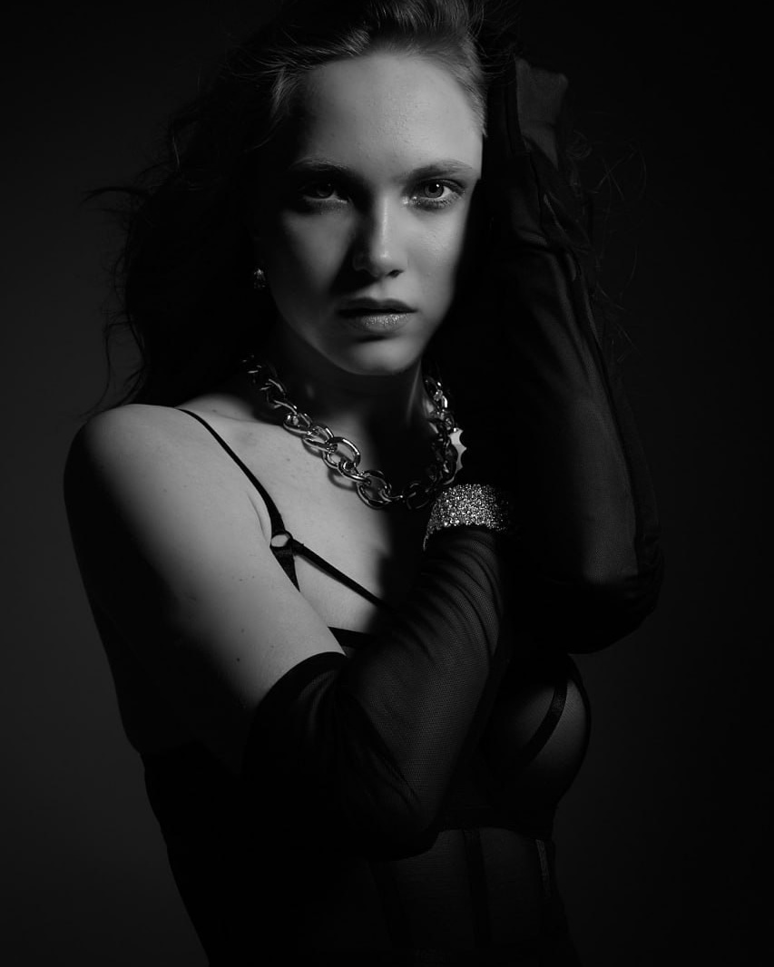 Черно-белый студийный портрет девушки в длинных черных перчатках.