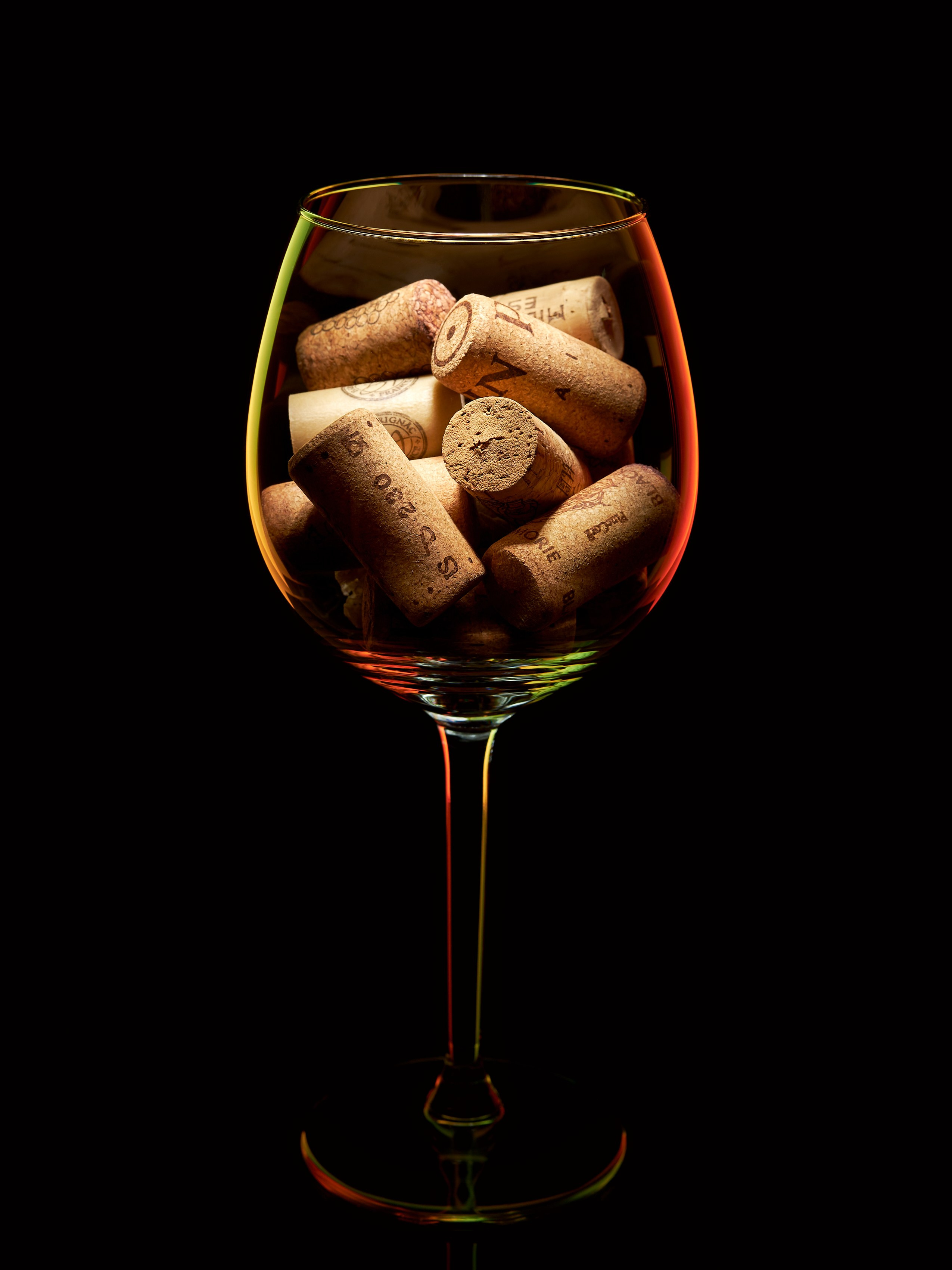 Бокал, наполненный винными пробками, на тёмном фоне с контрастной подсветкой, серия CONTAINMENT