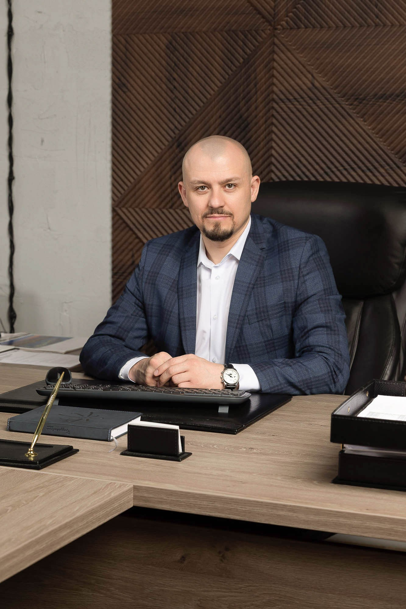 Серьезный деловой портрет в офисе на фоне коричневой стены