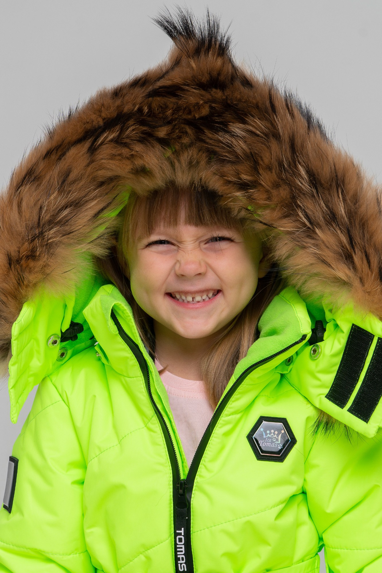 Девочка смеется в капюшоне с мехом