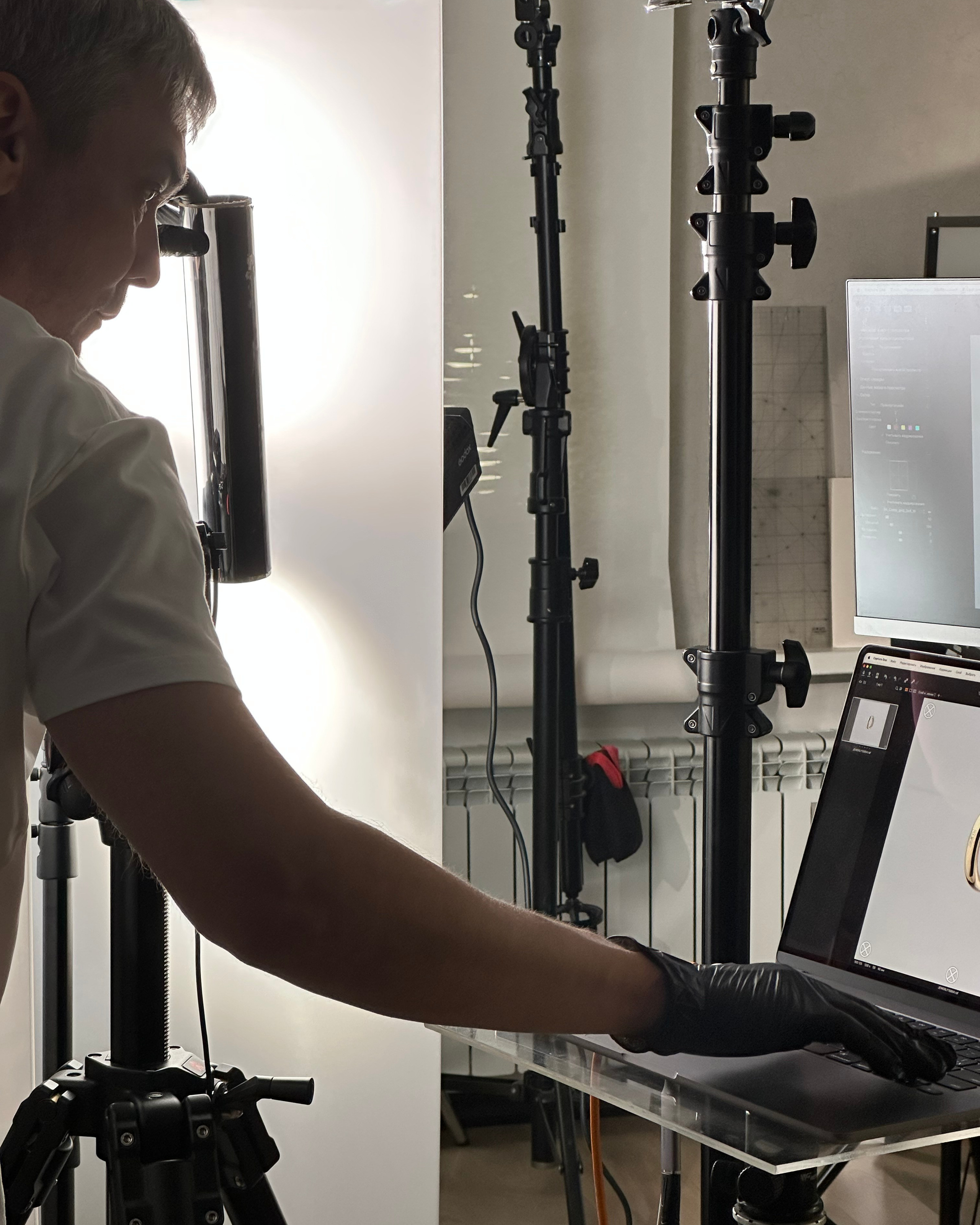 Бэкстейдж предметной фотосъёмки в студии — фотограф работает со светом и отражениями, готовит кадр к профессиональной ретуши