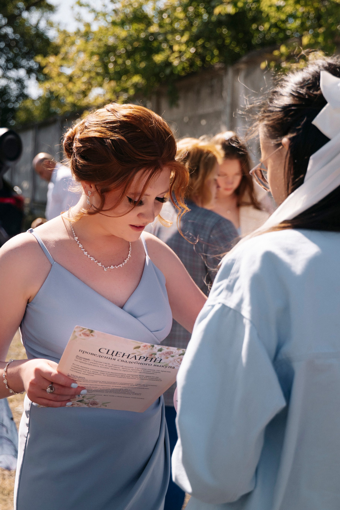 Крупный план свадебного букета невесты из полевых цветов на деревянном столе.Обручальные кольца на страницах старой книги в уютном интерьере.Свадебные приглашения, перчатки невесты и духи, разложенные на комоде в стиле ретро.