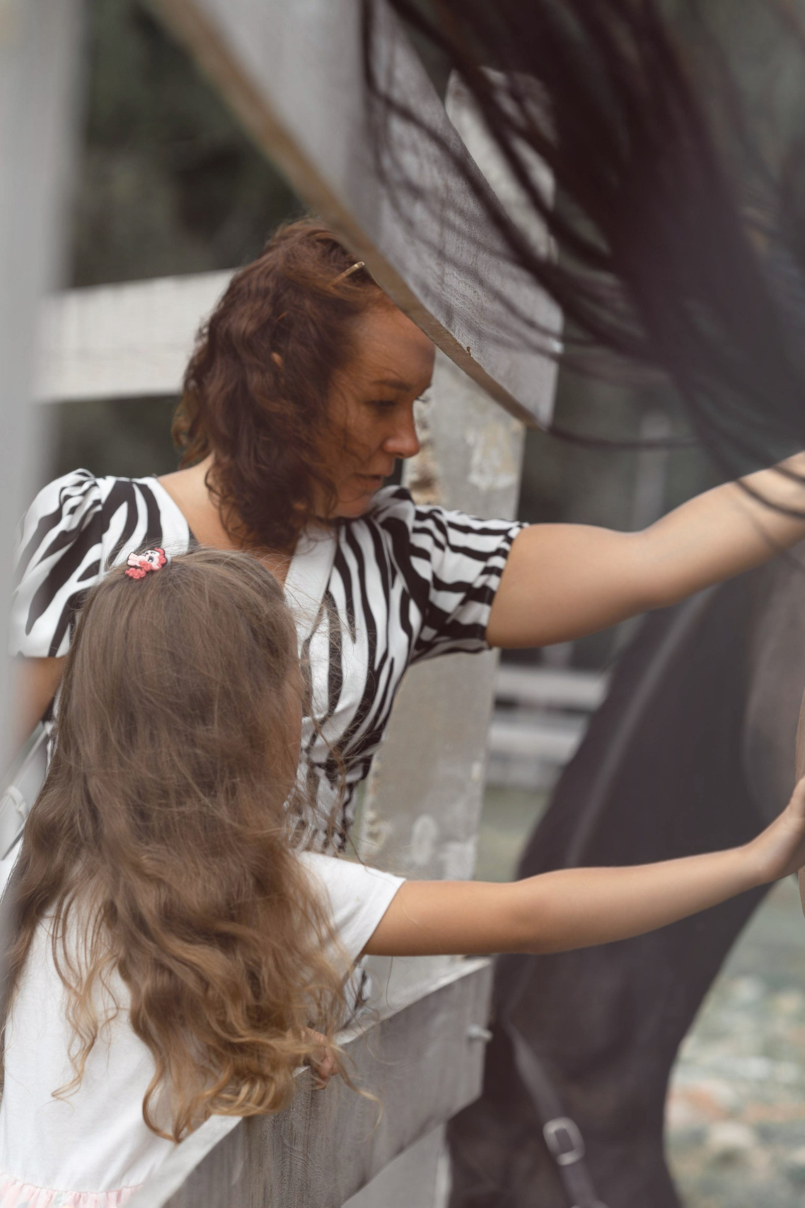 Маленькая девочка в купальнике поливают газон на своём участке