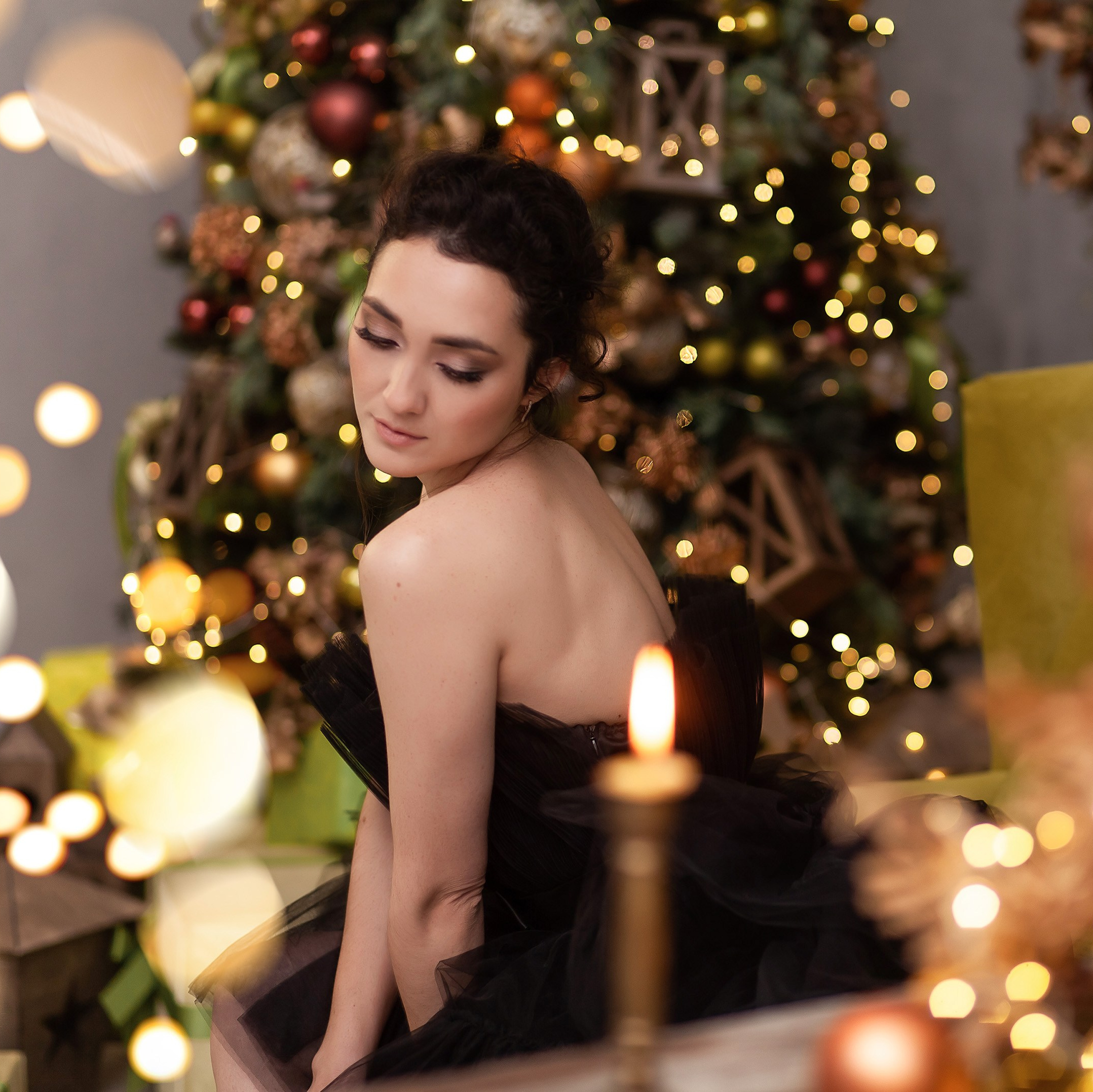 Портрет девушки в новогодних огнях со свечами