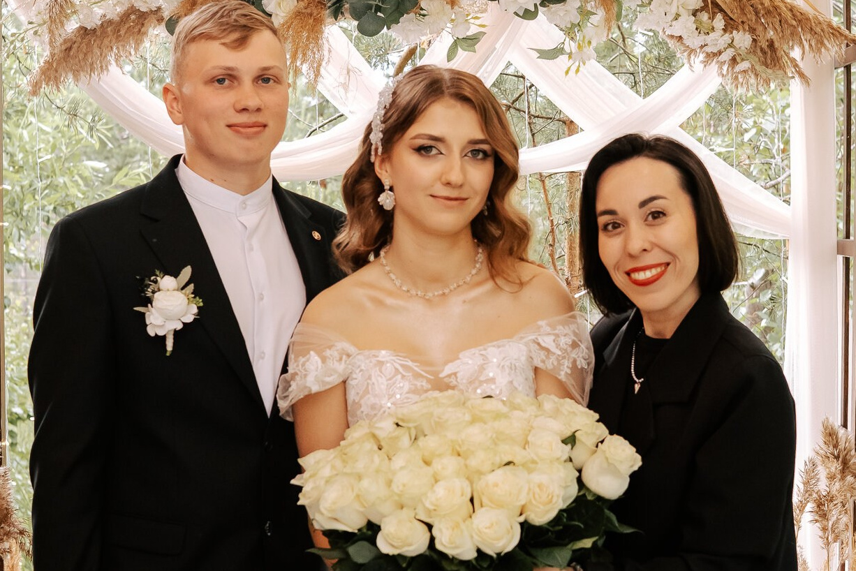 молодожены обнимают ведущую 