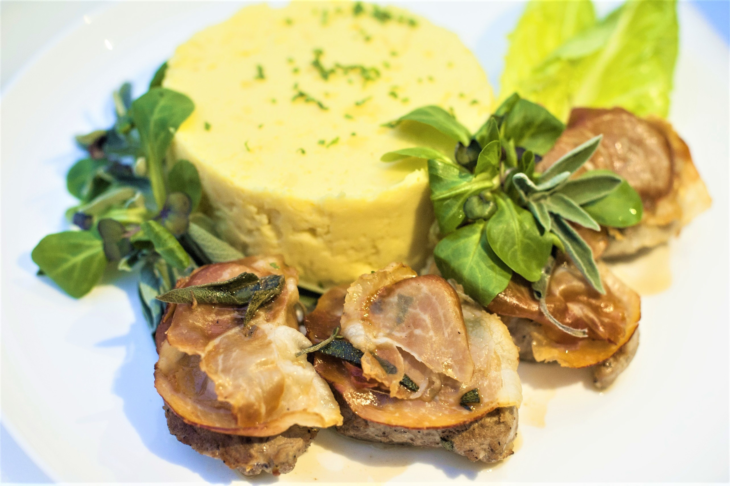 Медальоны из свиной вырезки с сыровяленым окороком и шалфеем, подается с картофельным пюре