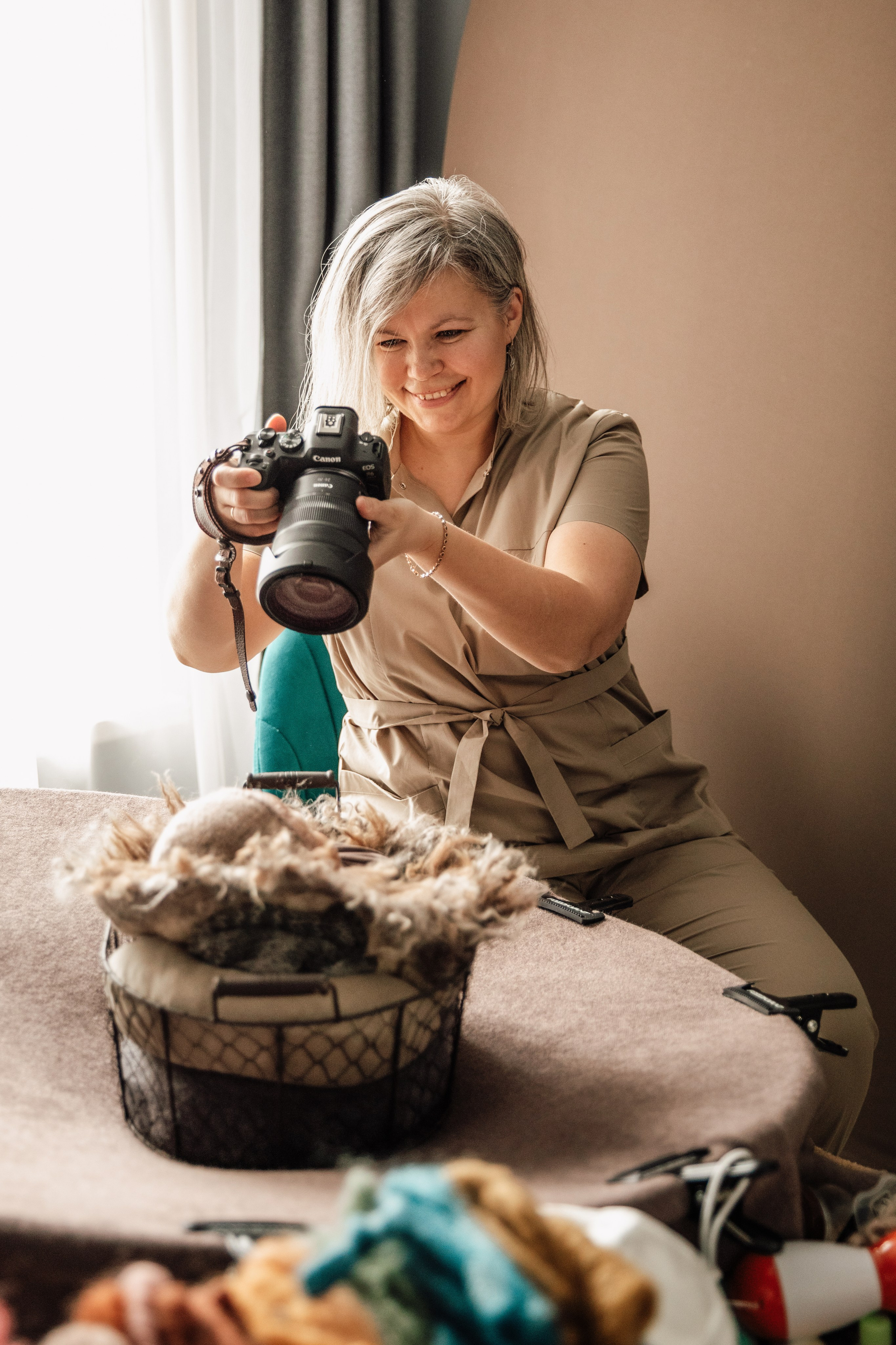 Newborn-фотограф Наташа Давыдова работает с новорожденным малышом.