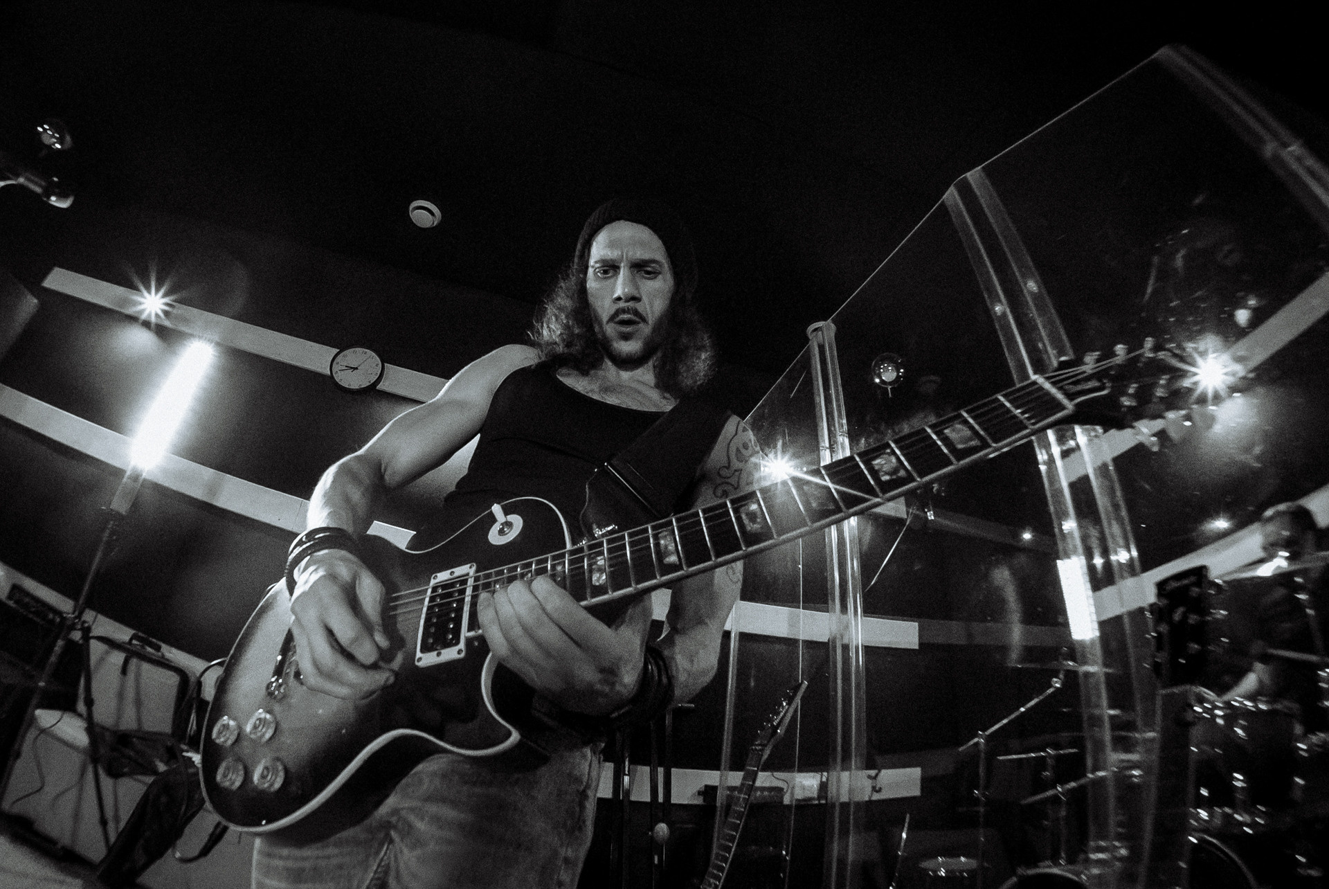 Мужчина играет на гитаре в звукозаписывающей студии